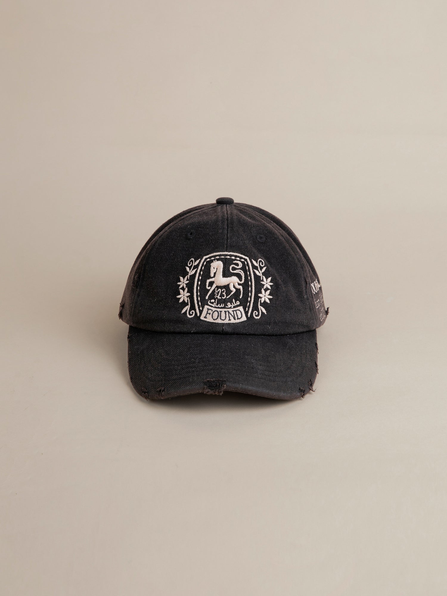 A worn black FOUND Logo Crest Cap with a vintage wash featuring a white embroidered logo that reads 