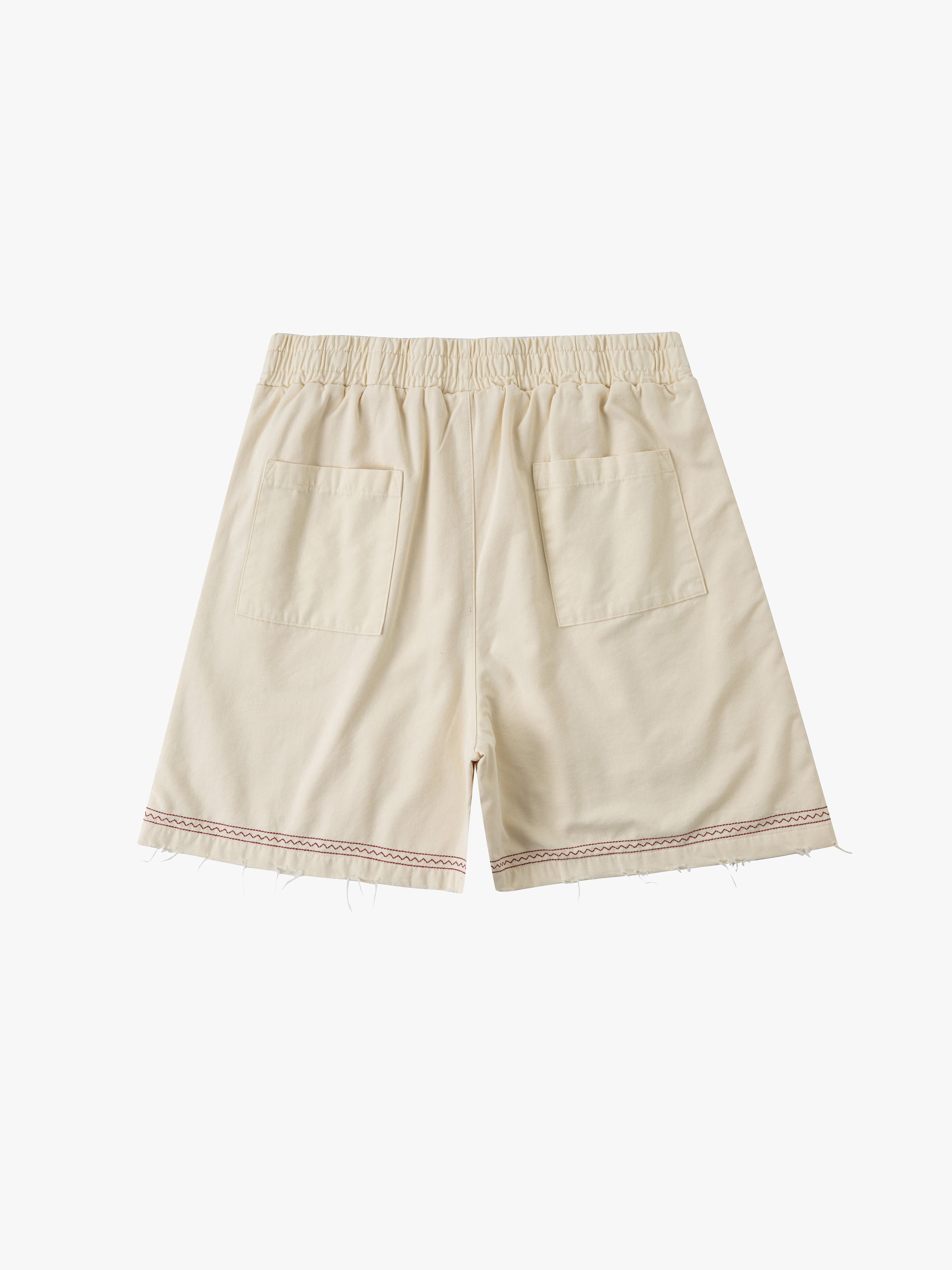 Profound's Embroidered Horse Shorts feature a beige cotton twill design with an elastic waistband, two back pockets, frayed hem detailing, and embroidered horse motifs.