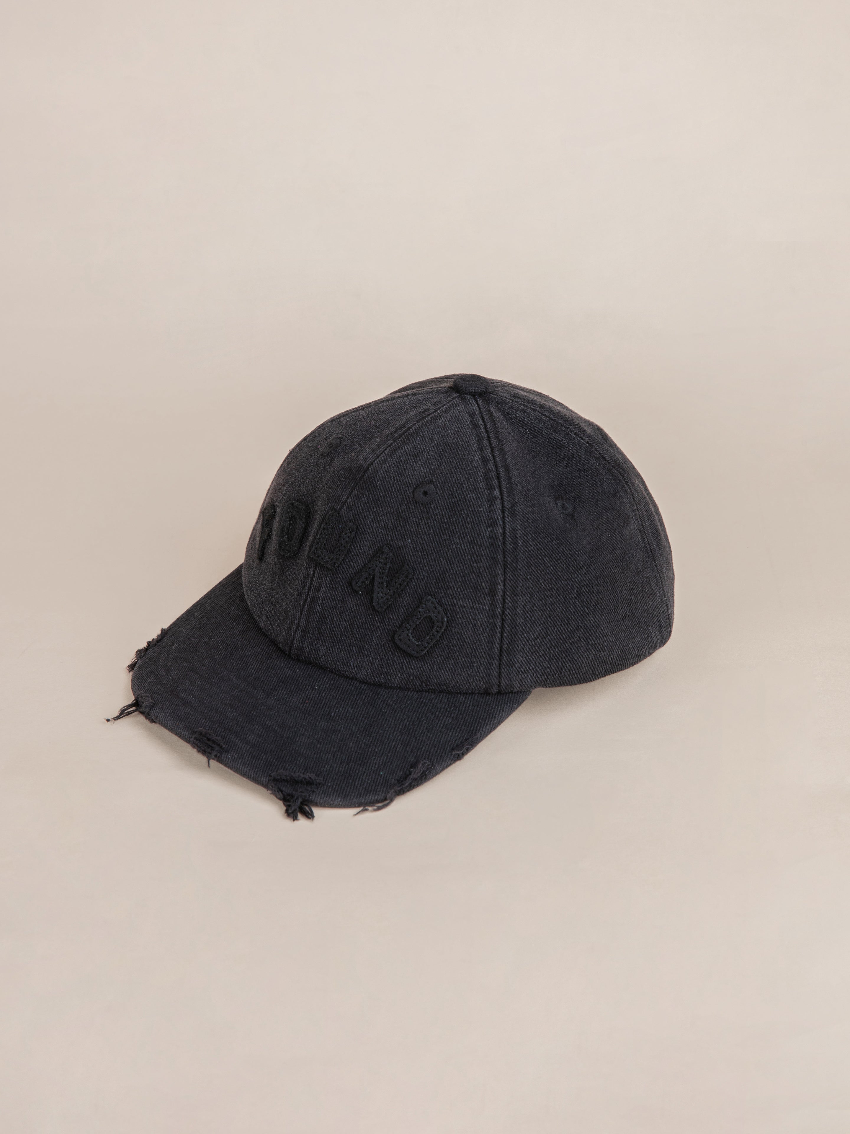 The Black Felt Patch Cap by FOUND features a hand-distressed brim and frayed edges, with raised lettering on the front, offering a vintage washed vibe.