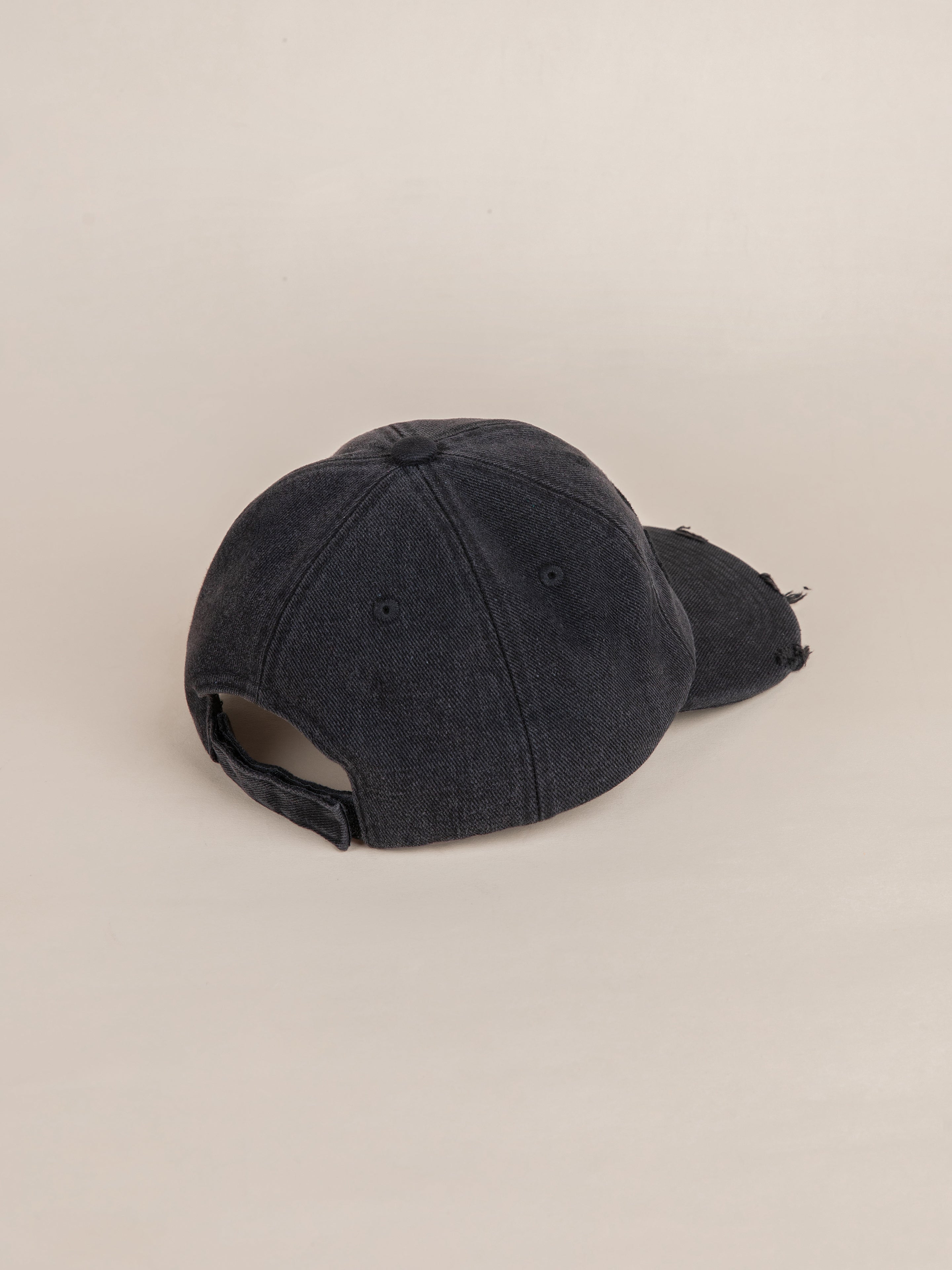 A rear perspective of the Black Felt Patch Cap by FOUND, featuring a vintage washed black denim appearance with an adjustable strap and a subtly distressed brim.