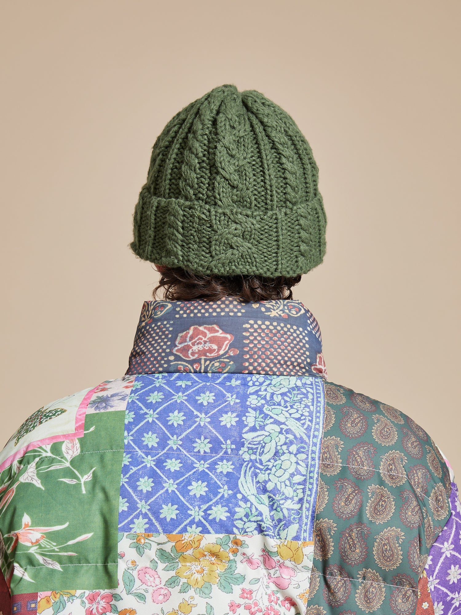 The back of a man wearing the Profound Forest Cable Knit Beanie.