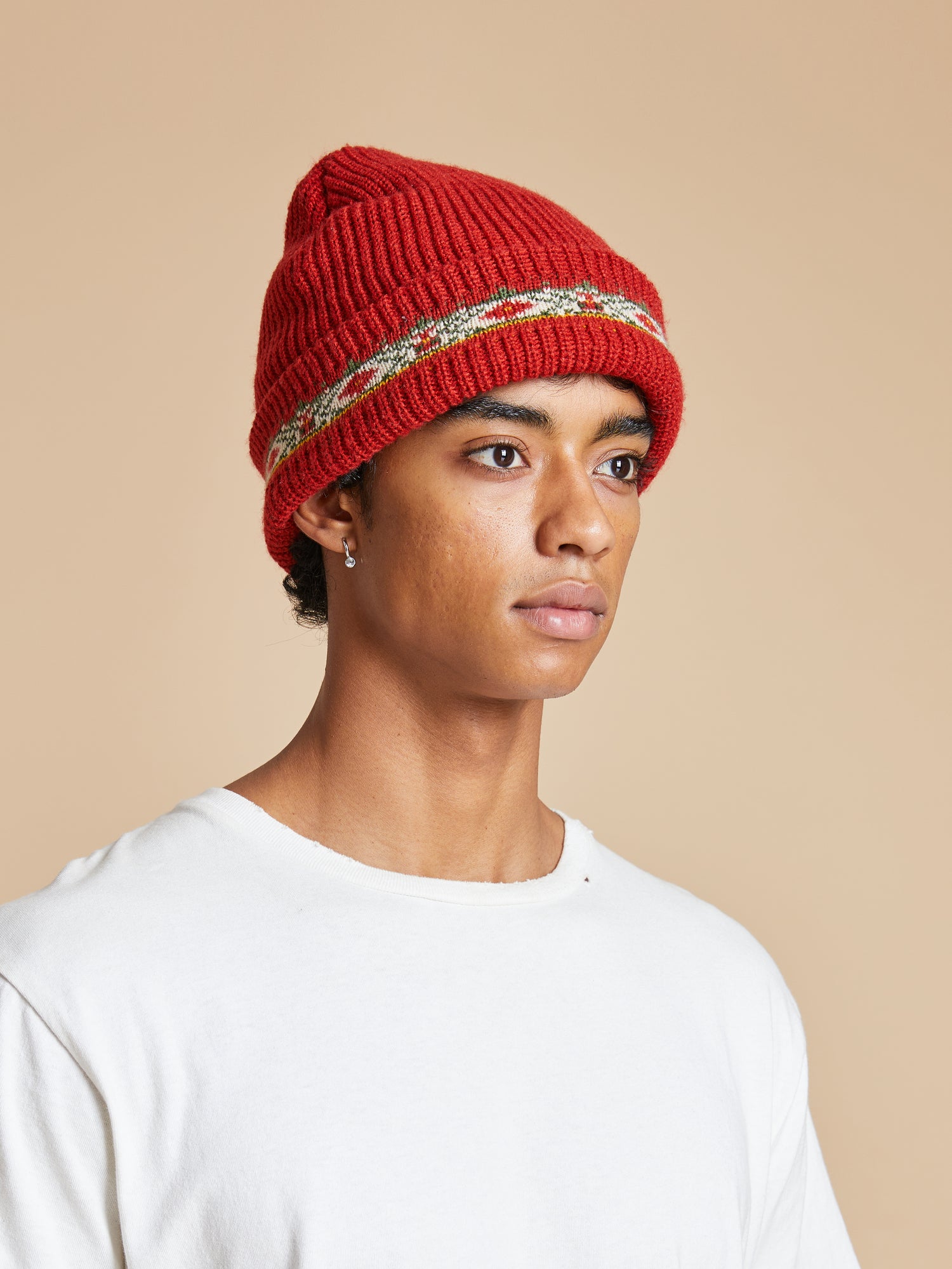 A young man wearing a red Profound Ajrak Beanie.