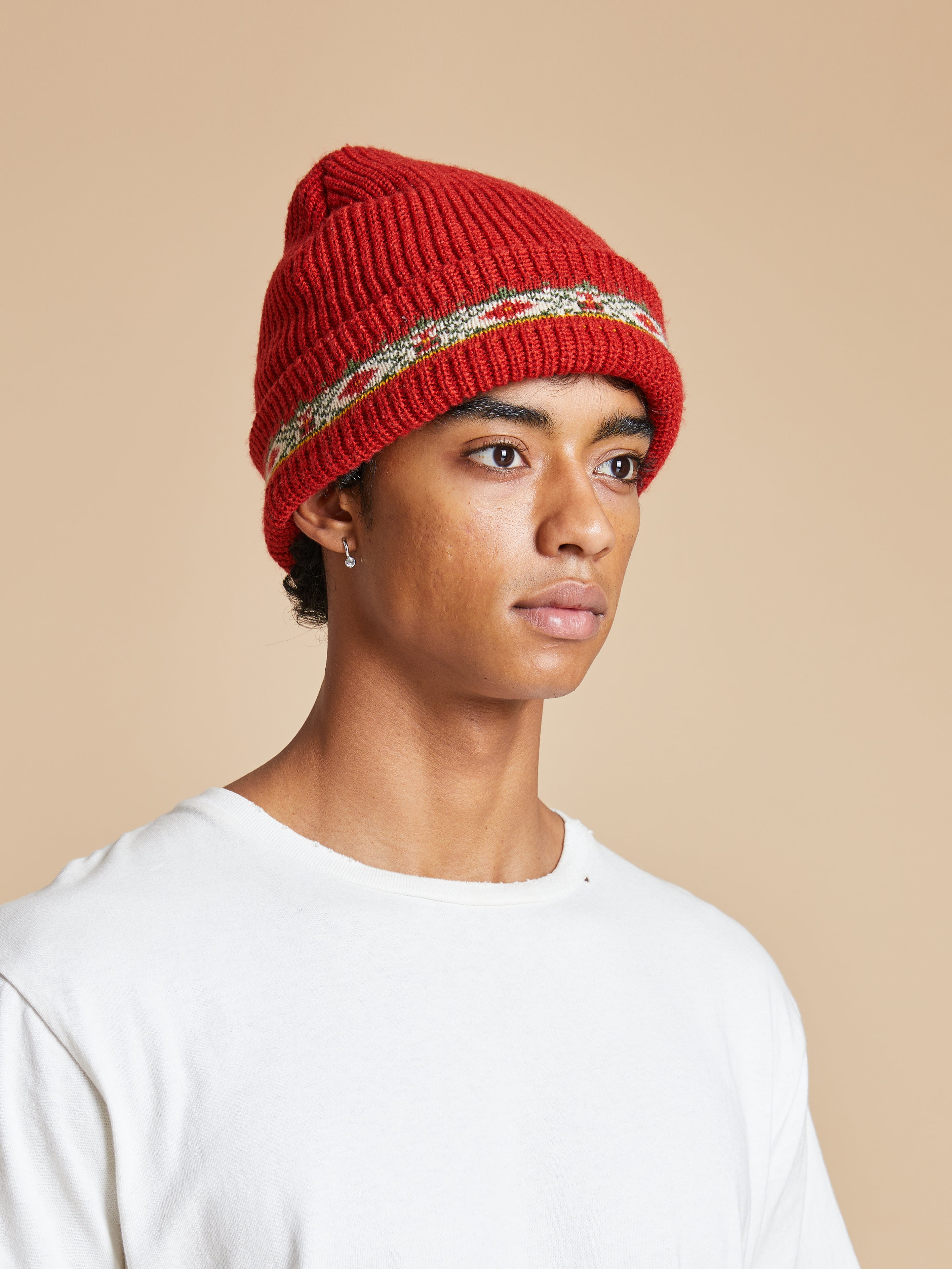 A young man wearing a red Profound Ajrak Beanie.