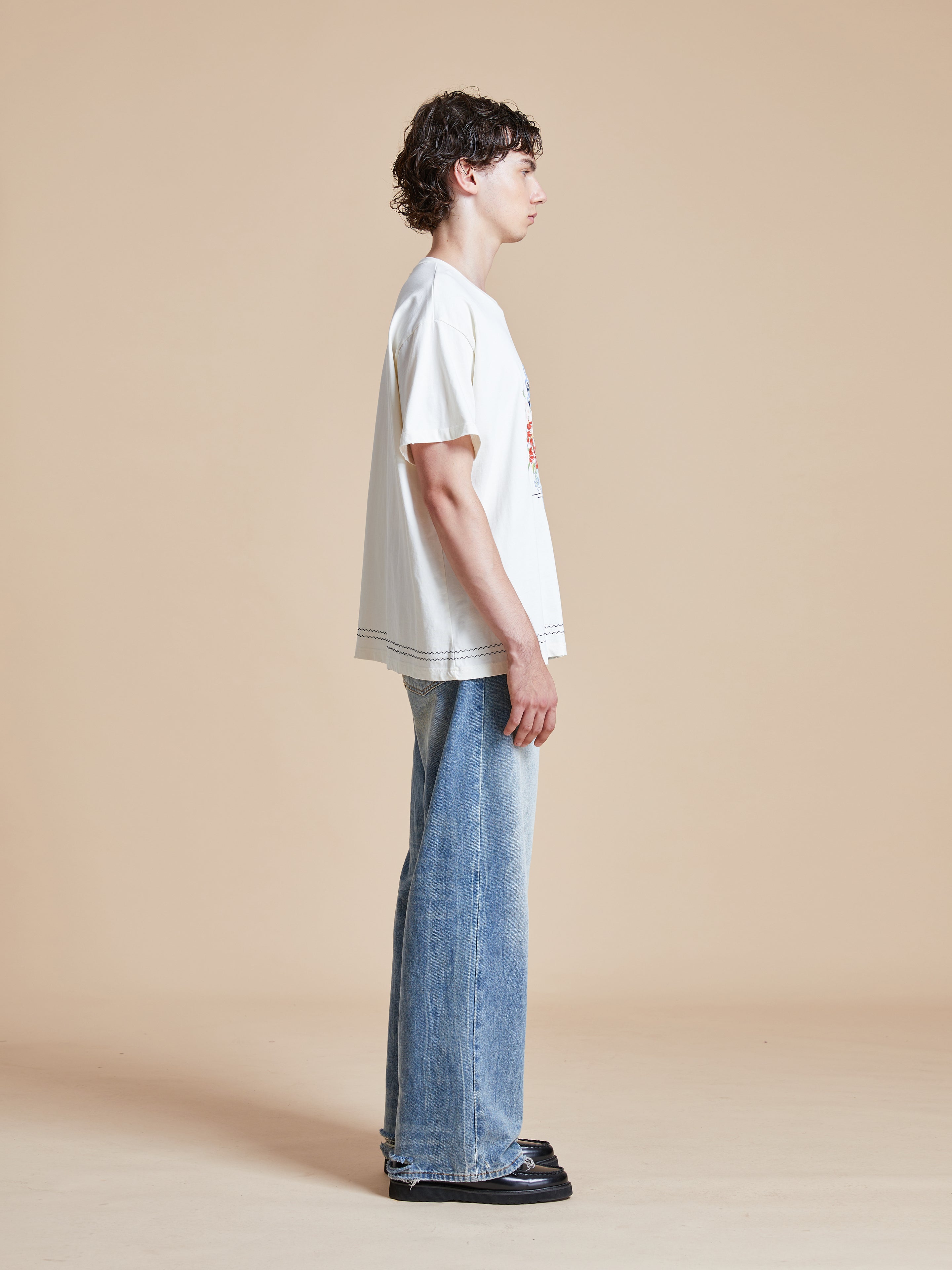 A model wearing a Found Bouquet Flowers Tee and jeans.