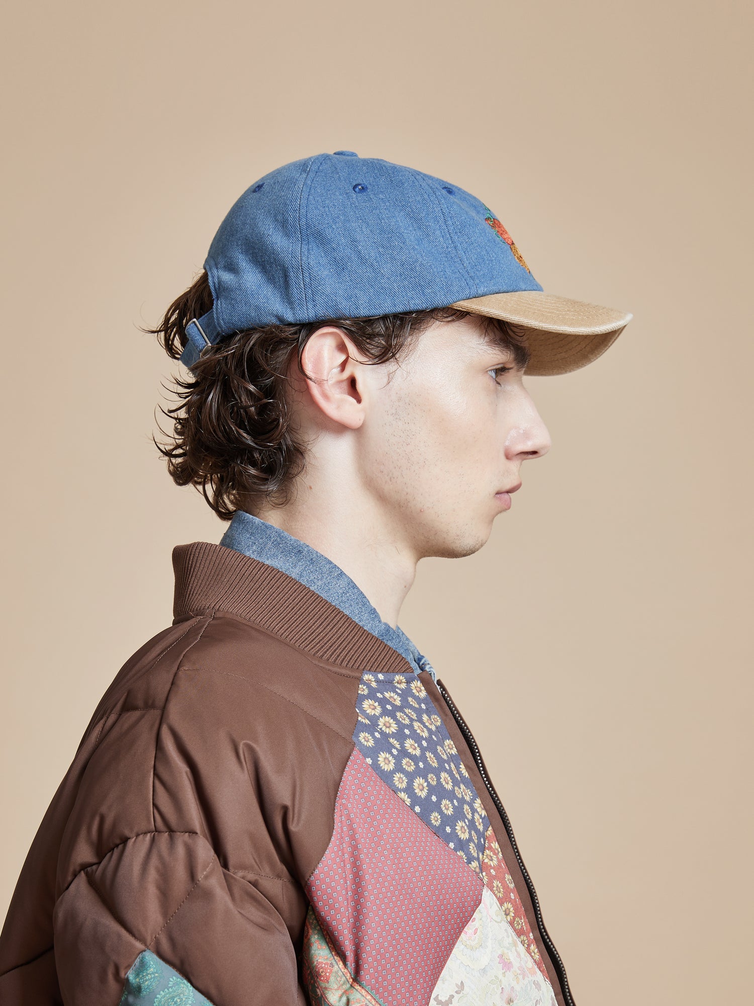 A young man wearing a Found Butterfly House Denim Cap.