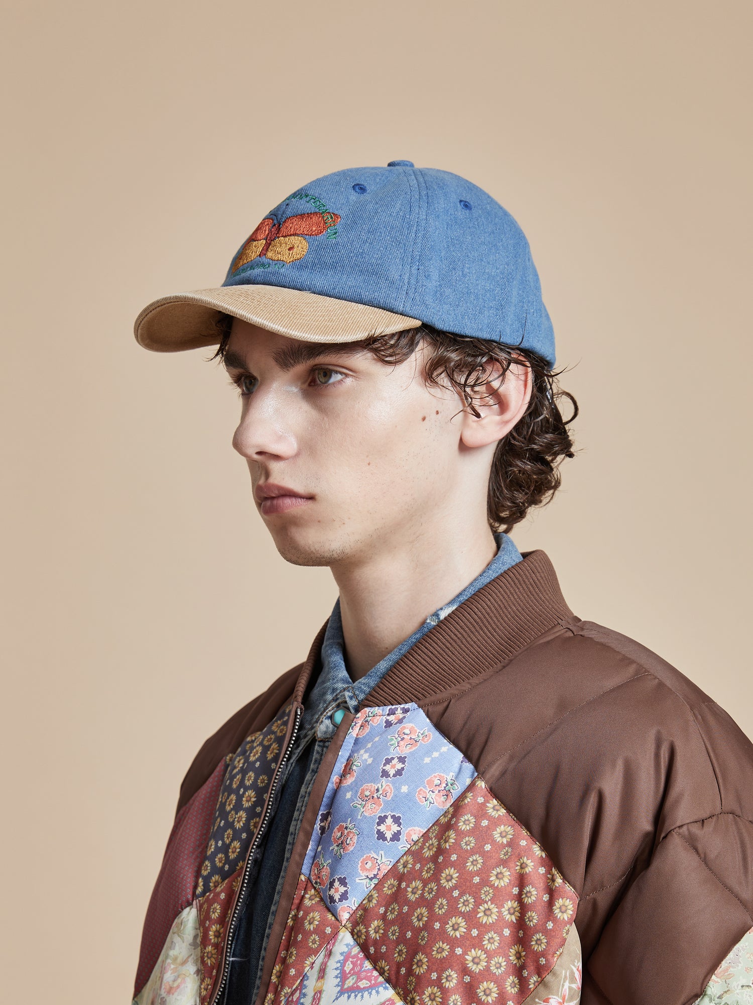A young man wearing a Found Butterfly House Denim Cap jacket and hat.
