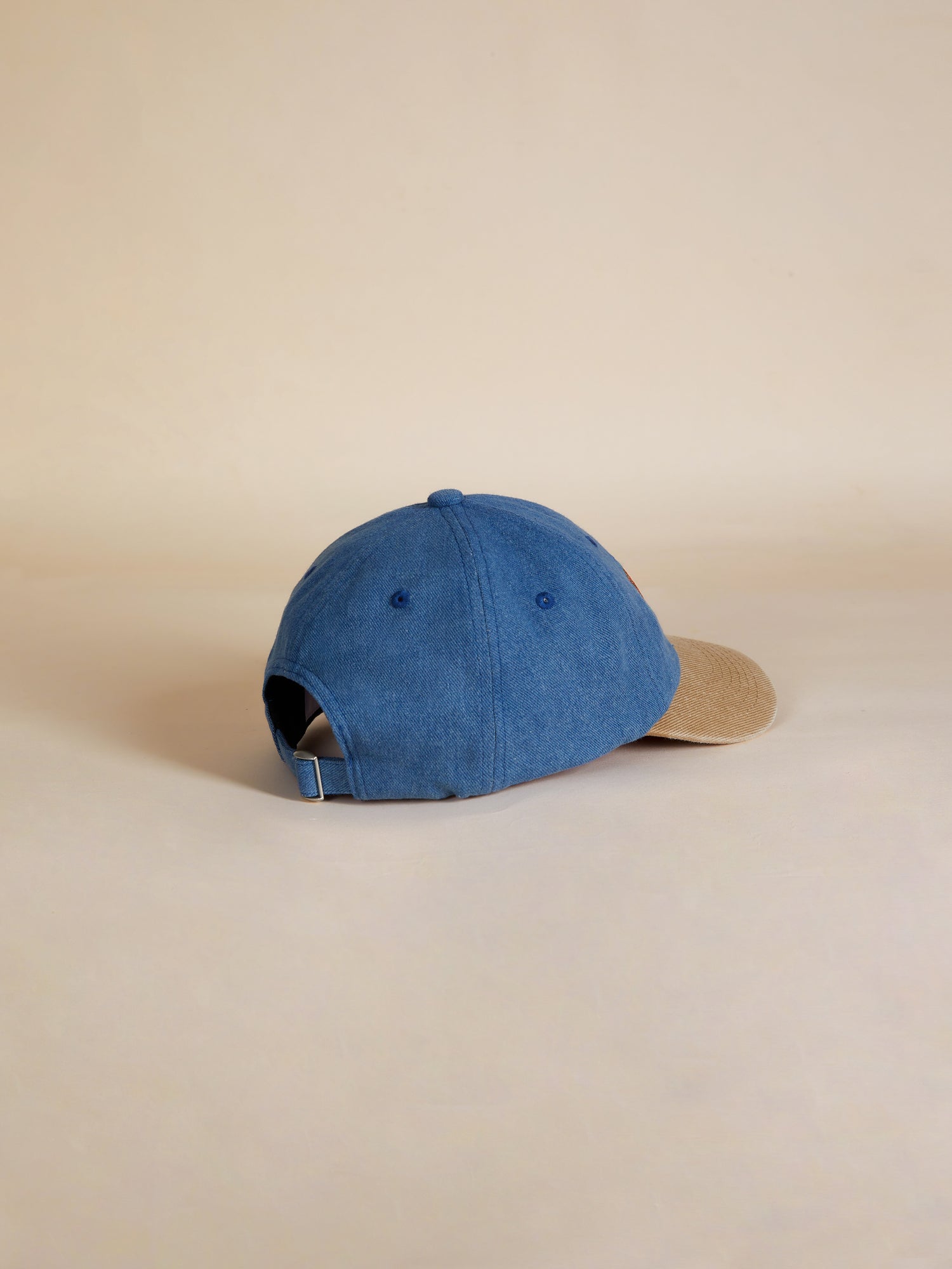A Found Butterfly House Denim Cap on a beige background.