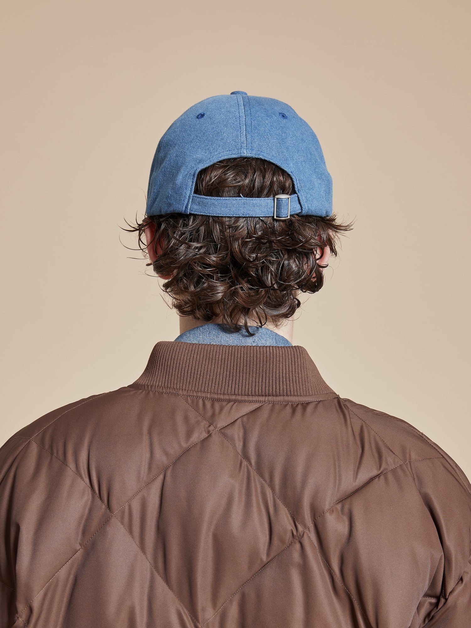 The back view of a man wearing a Found Butterfly House Denim Cap.