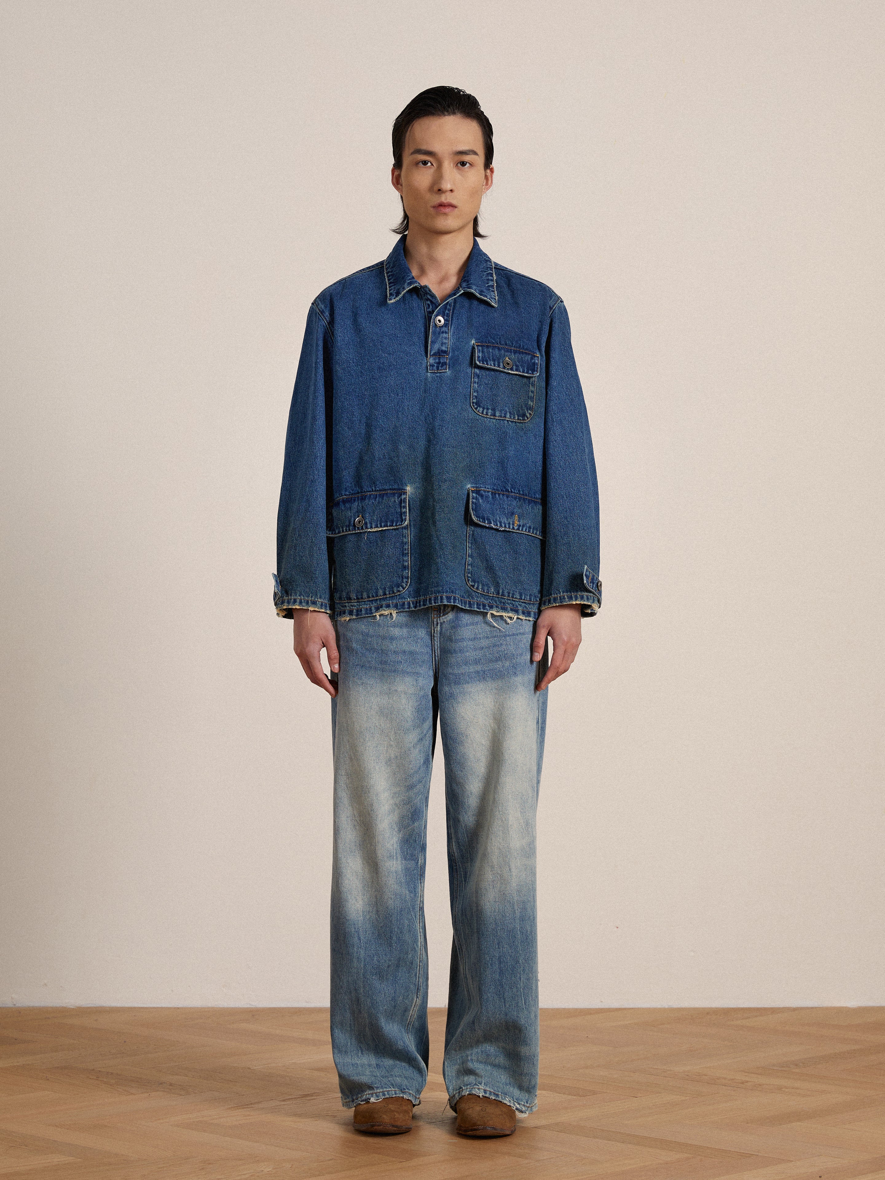 A man in a Azin Denim Pullover Work Shirt work shirt and jeans stands in a neutral pose against a beige backdrop, looking directly at the camera.