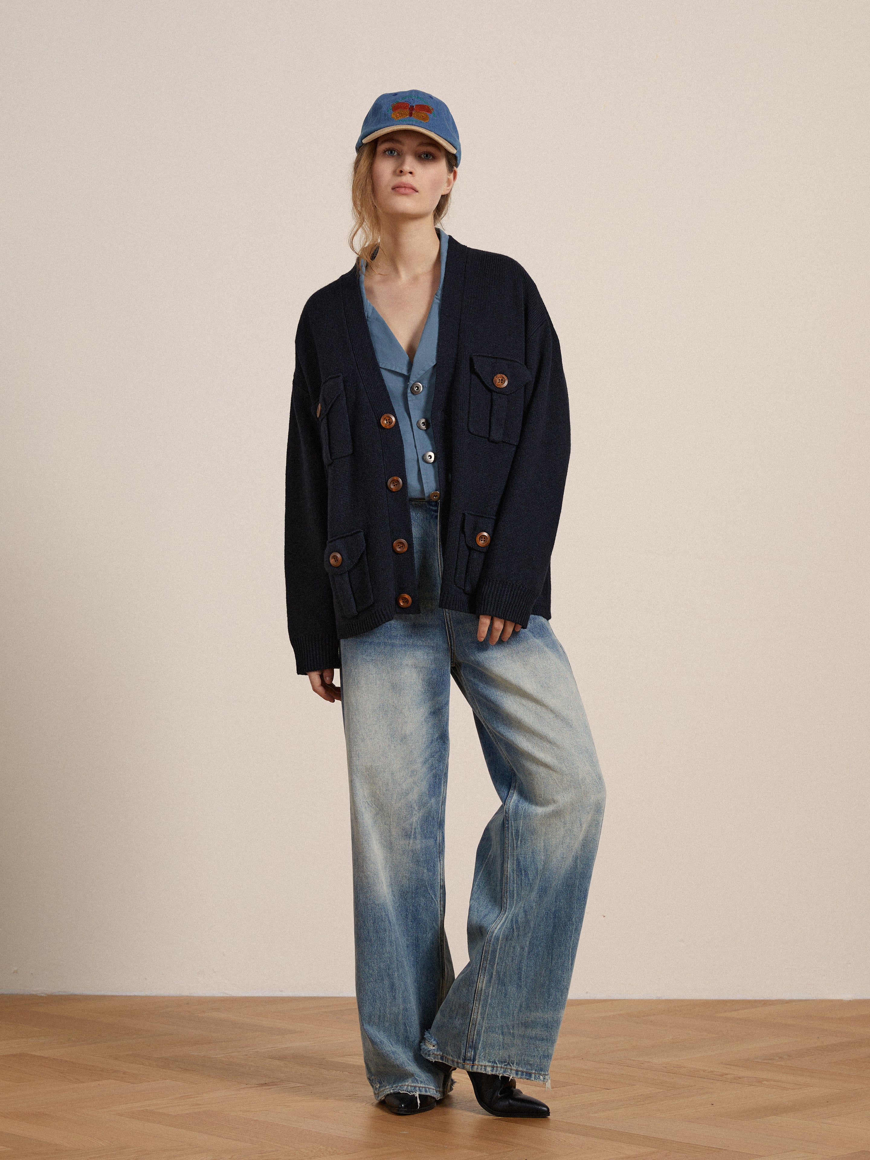 A woman in blue jeans and a Found Patina Work Jacket is standing on a wooden floor.