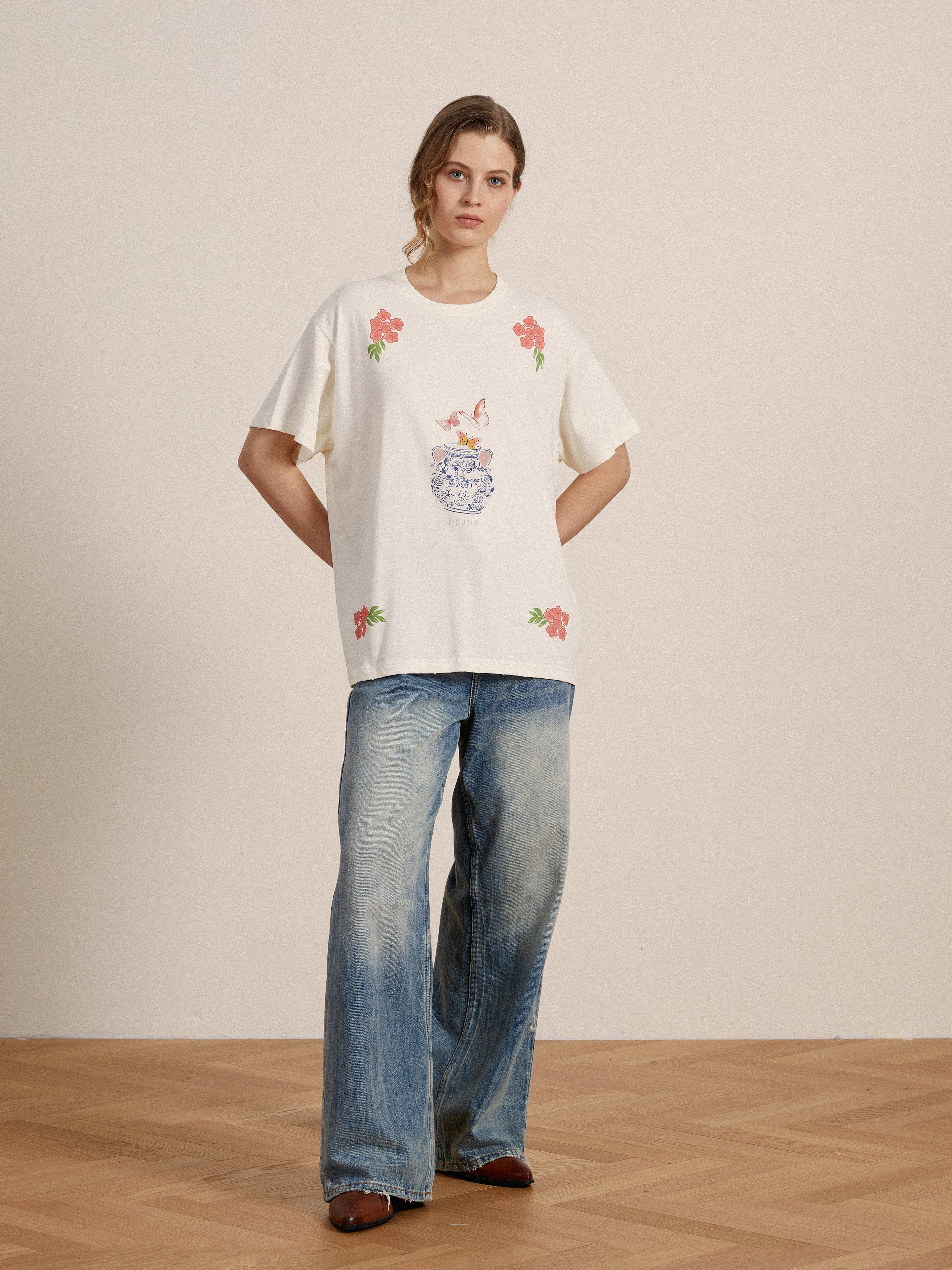 A woman wearing an embroidered Found Flower Pot Tee and lacy baggy jeans.