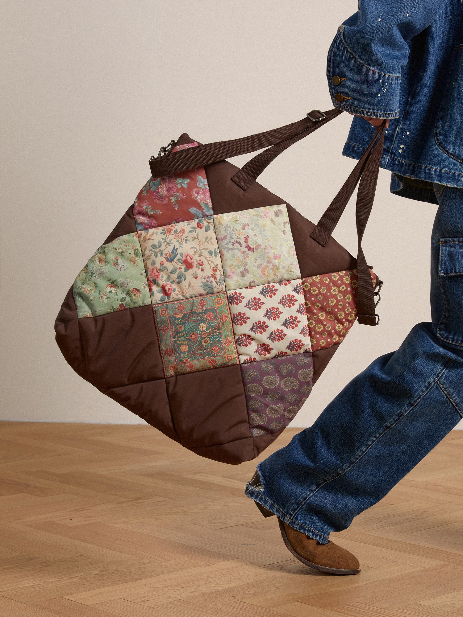 A woman carrying a Profound Parisa Quilted Tapestry Bag.