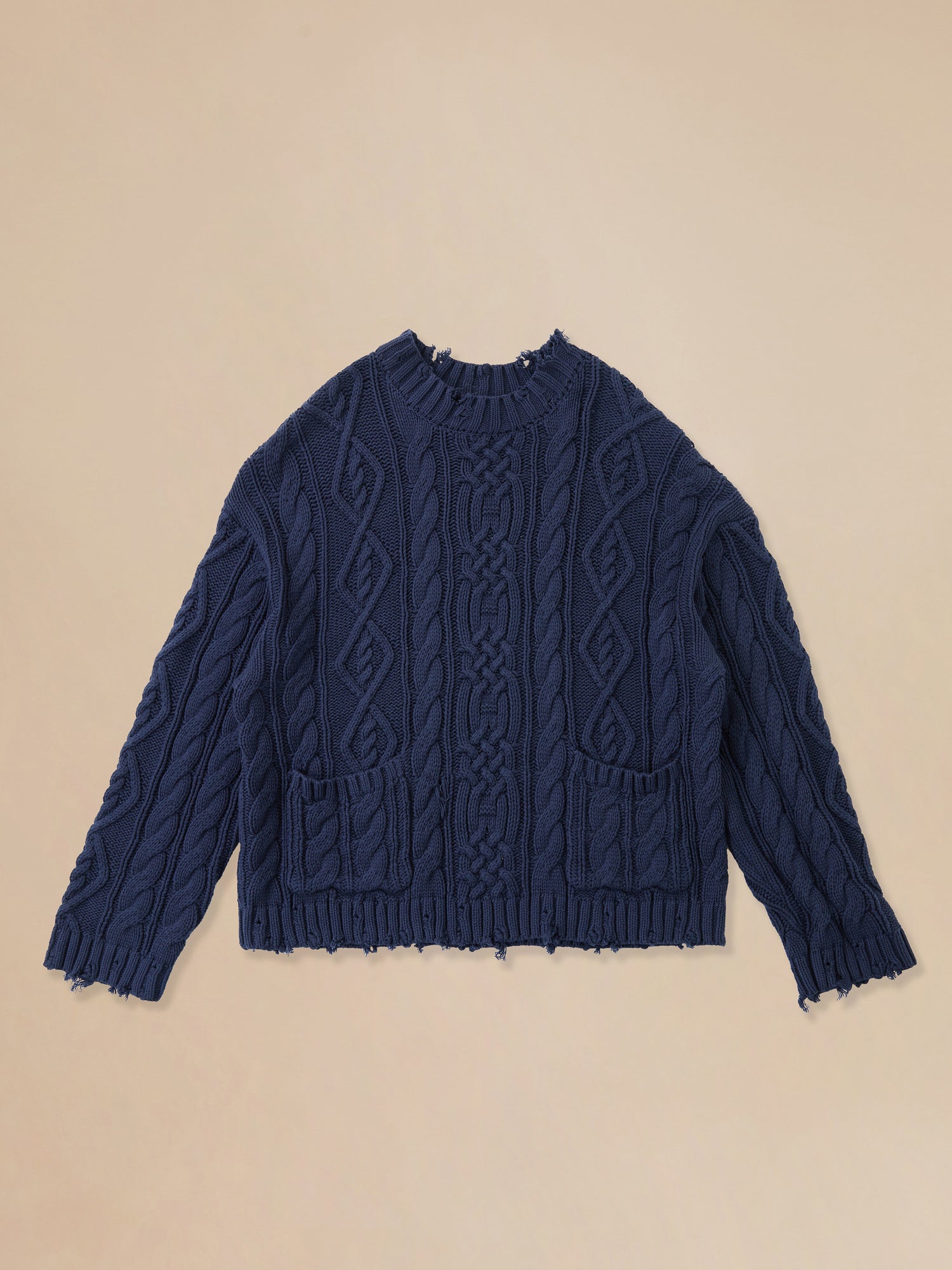 A blue Coming Soon | Astral Distressed Cable Knit Sweater on a beige background by Found.