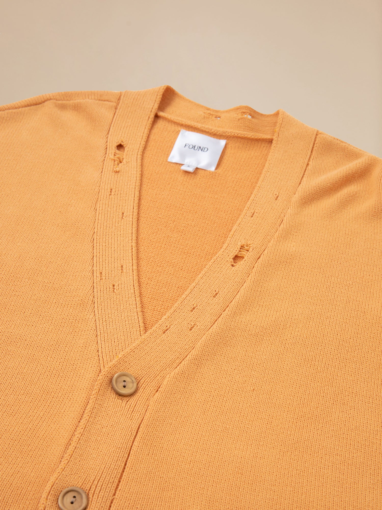 A Cadmium Distressed Cardigan by Found with buttons on the front.