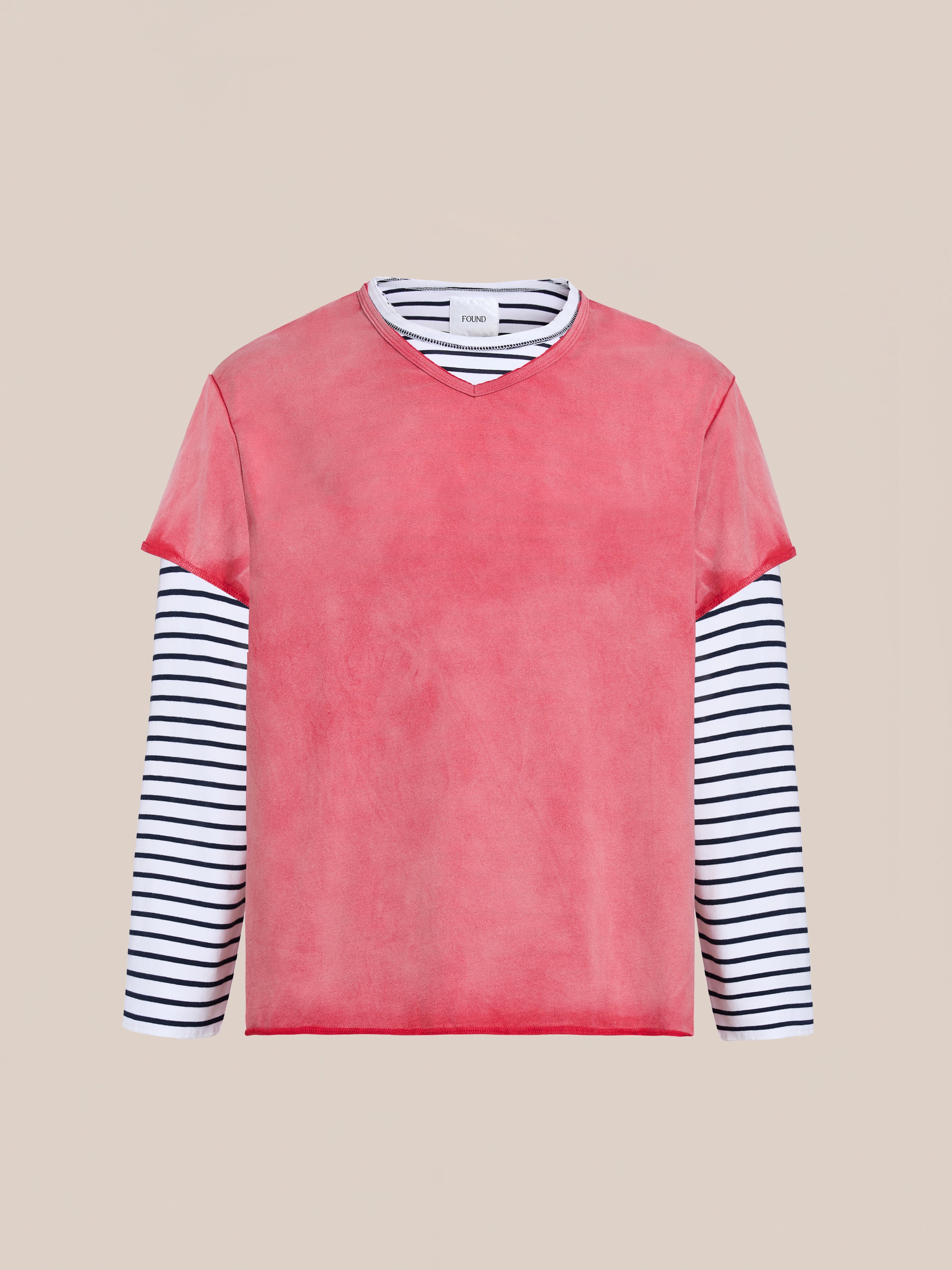 FOUND’s Double Layer LS Tee in unisex relaxed fit features black and white stripes under a solid pink short-sleeve top, shown against a plain beige background.