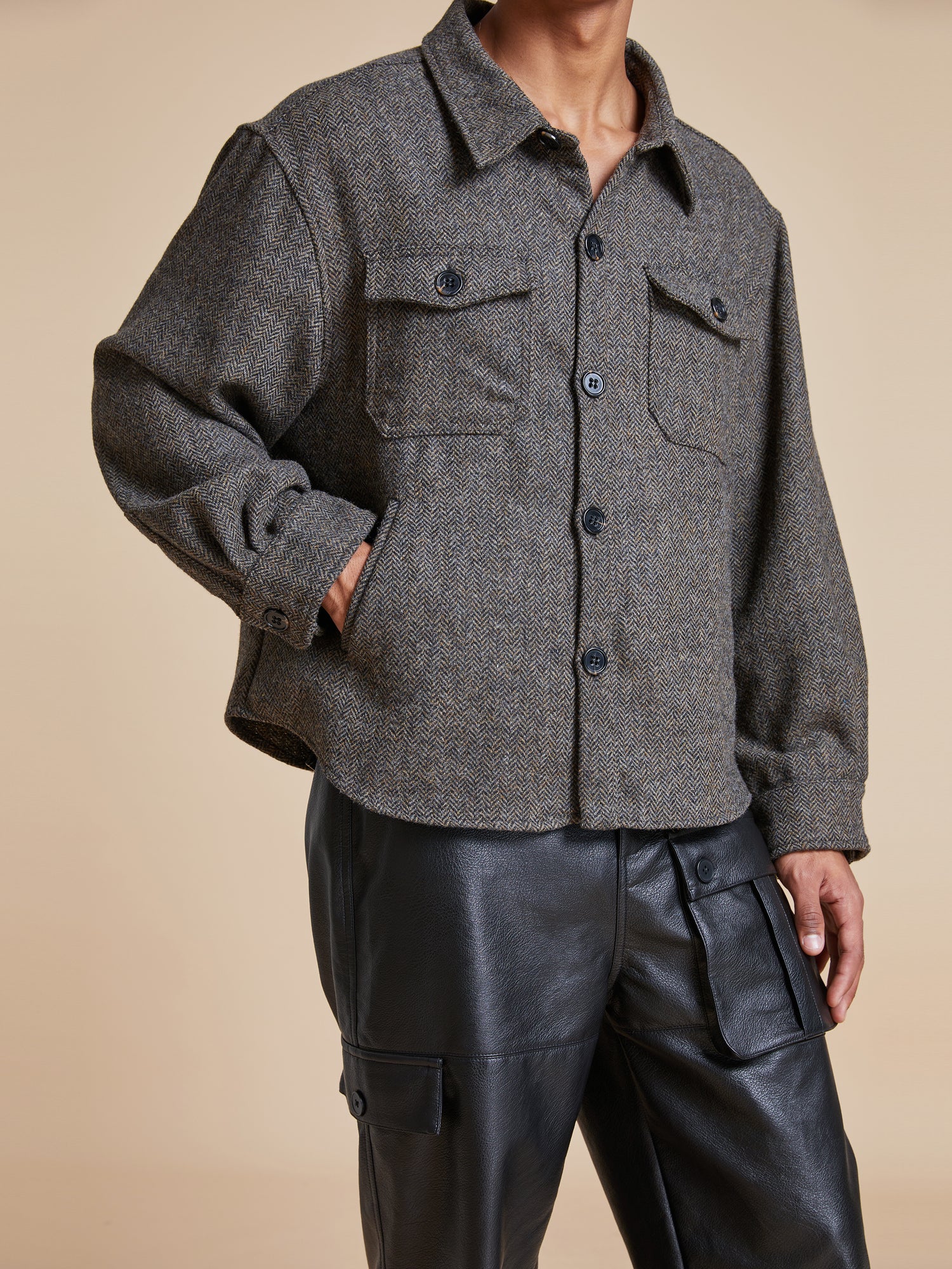 The model is wearing a Found Raven Herringbone Overshirt and leather pants.