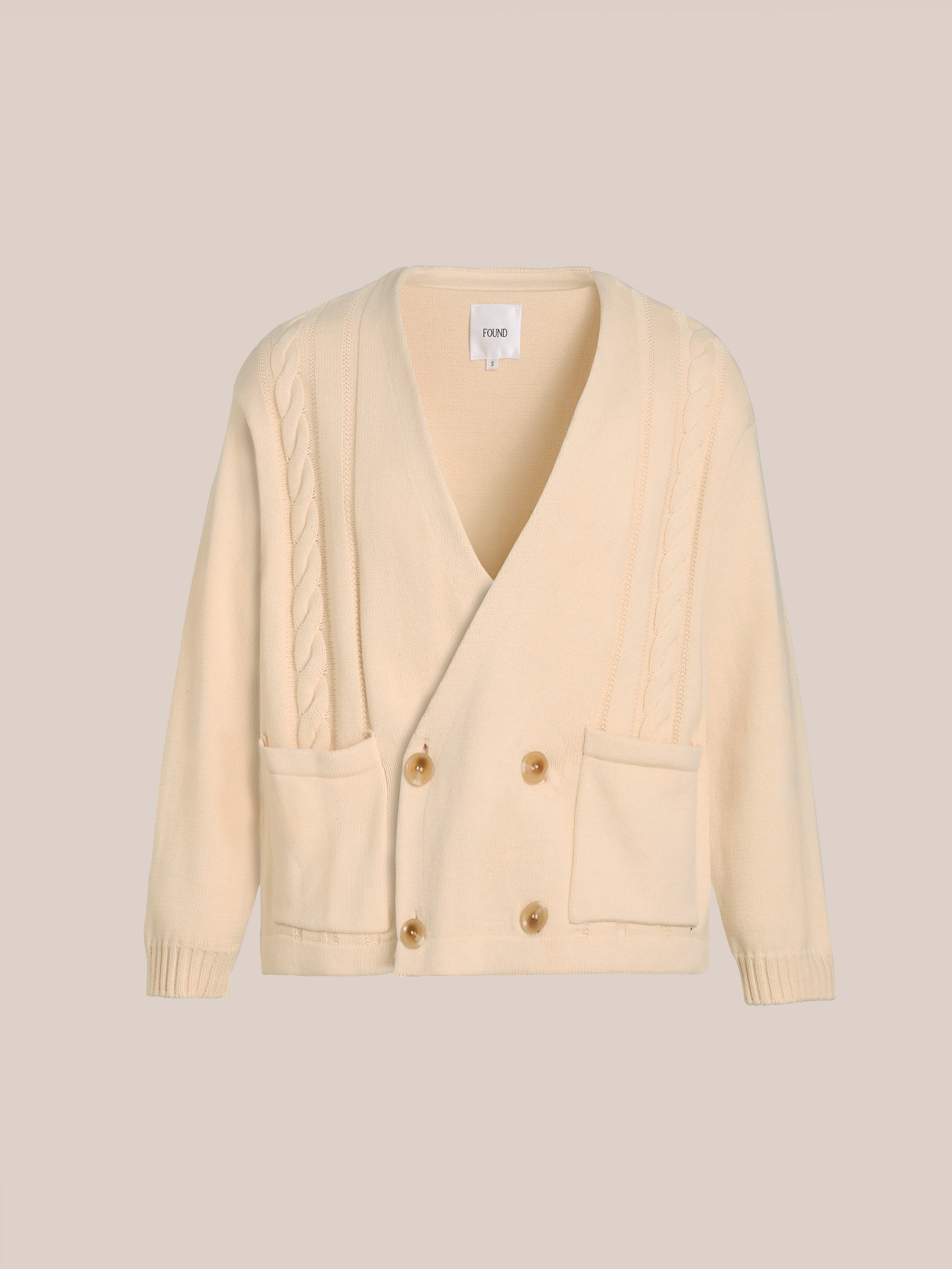 The FOUND Double Breasted Knit Cardigan is a beige, midweight cotton blend with cable-knit designs, two front pockets, and four wooden buttons for a relaxed fit.