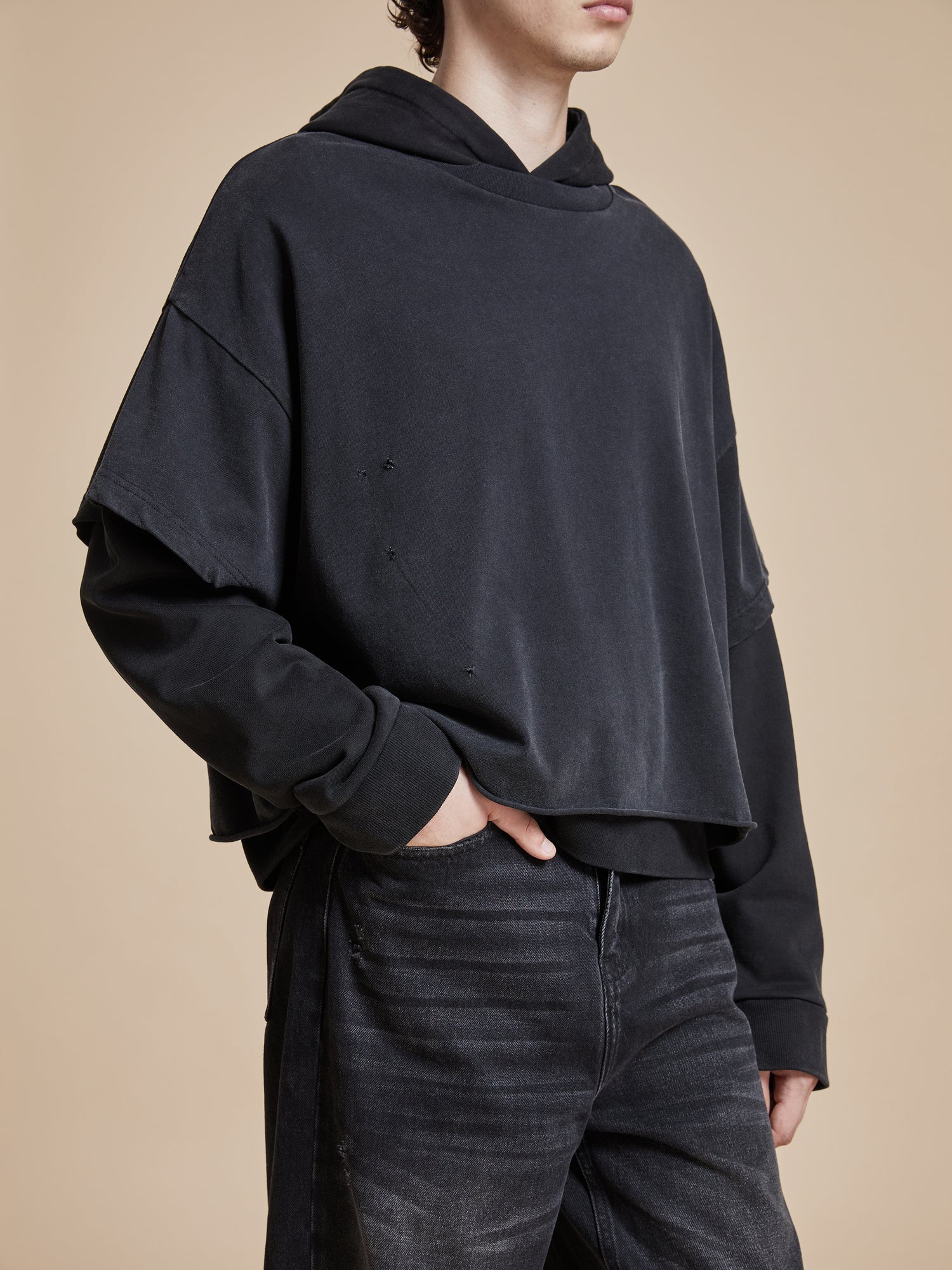 A man wearing a Found Double Layer Hoodie and jeans.