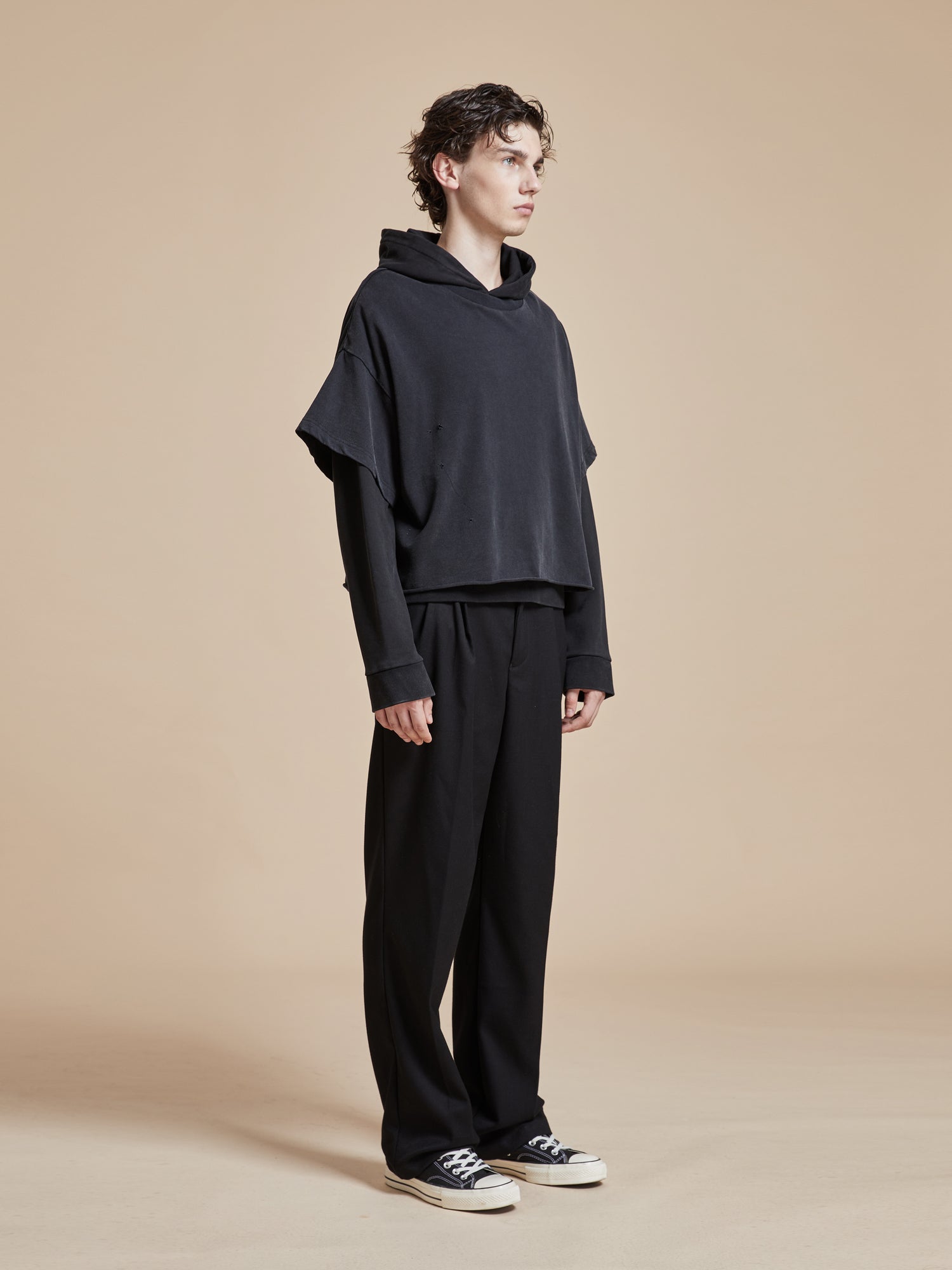 The model is wearing a Found double layer hoodie and black pants.