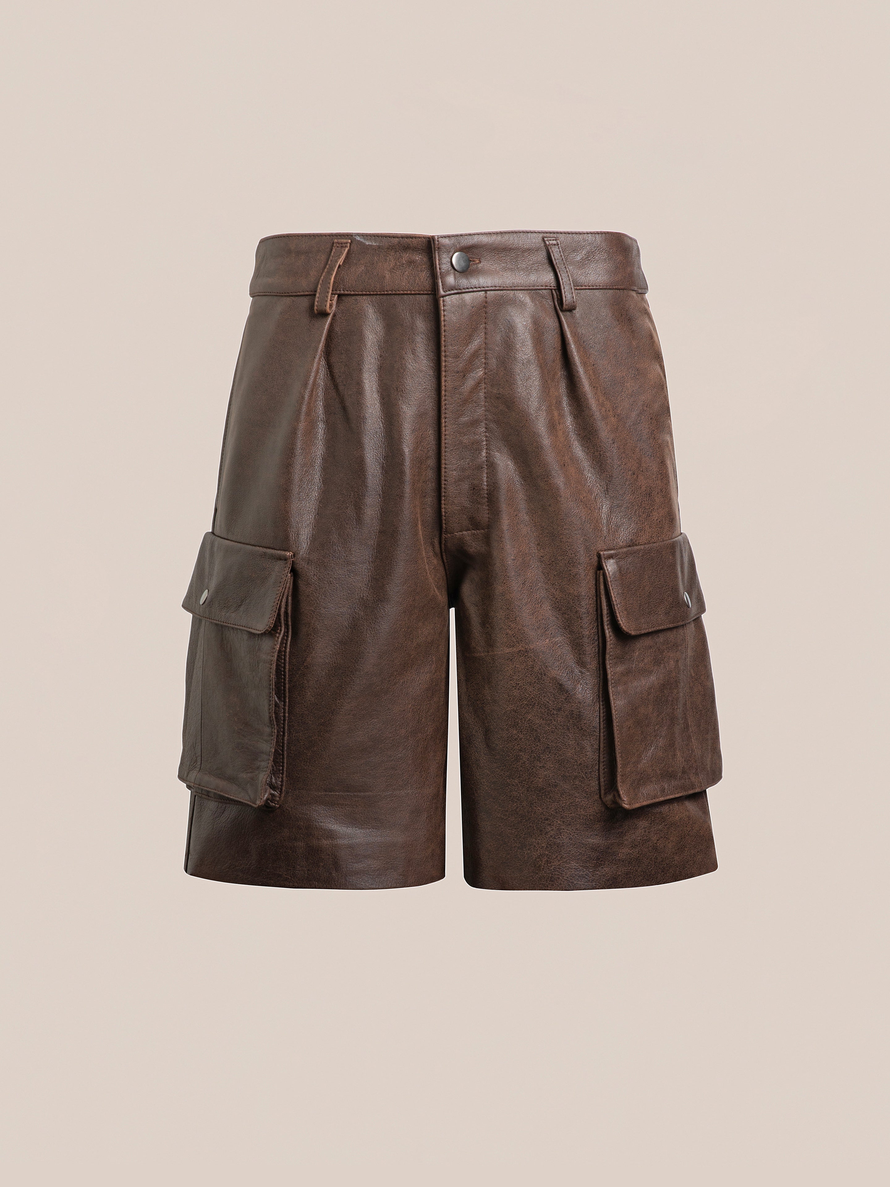 Found's Dusk Distressed Genuine Leather Cargo Shorts offer a unisex relaxed fit, featuring side pockets and a front button closure. Crafted from ethically sourced materials, these shorts are perfect for any wardrobe, showcased on a plain background.