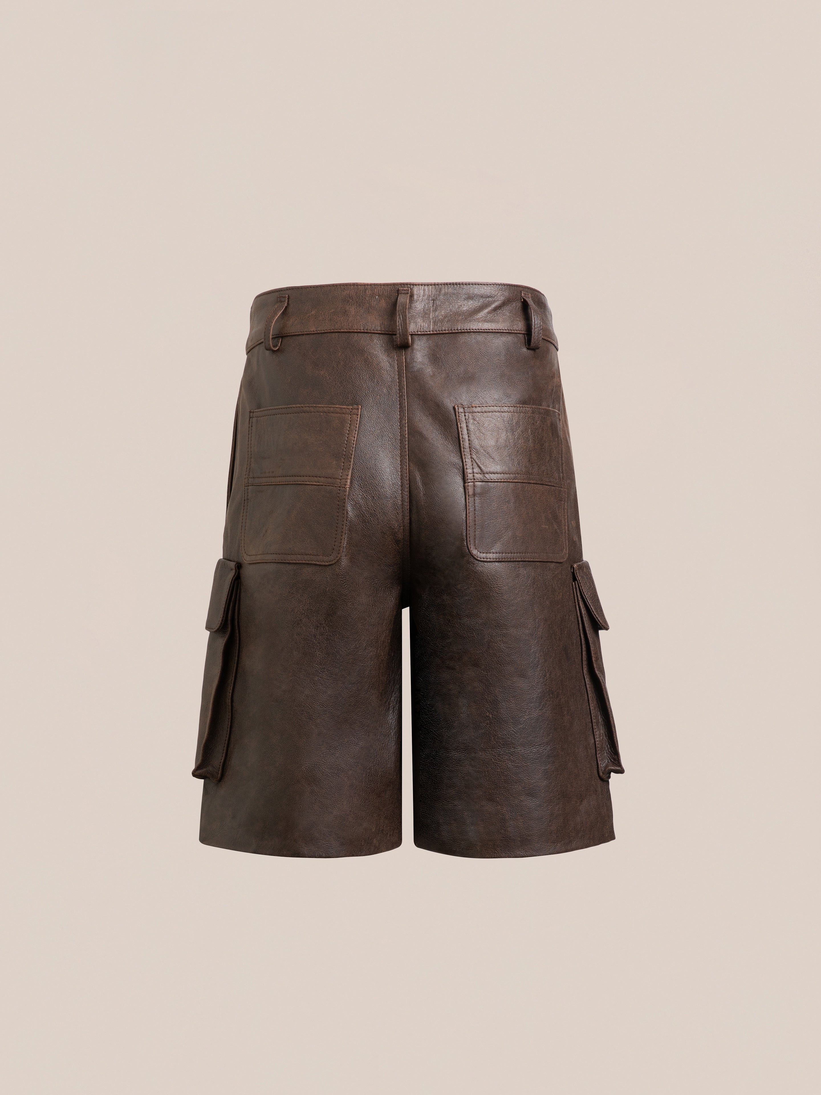 The Dusk Distressed Genuine Leather Cargo Shorts by Found offer a unisex relaxed fit, complete with belt loops, two back pockets, and two side pockets, all set against a neutral backdrop.