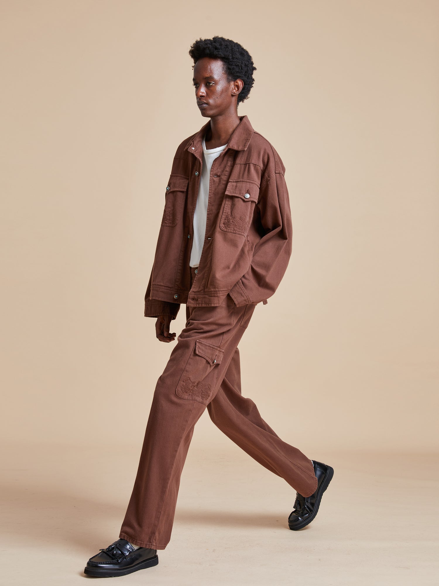 The model is wearing Dusky Western Cargo Jeans by Found and a white shirt.