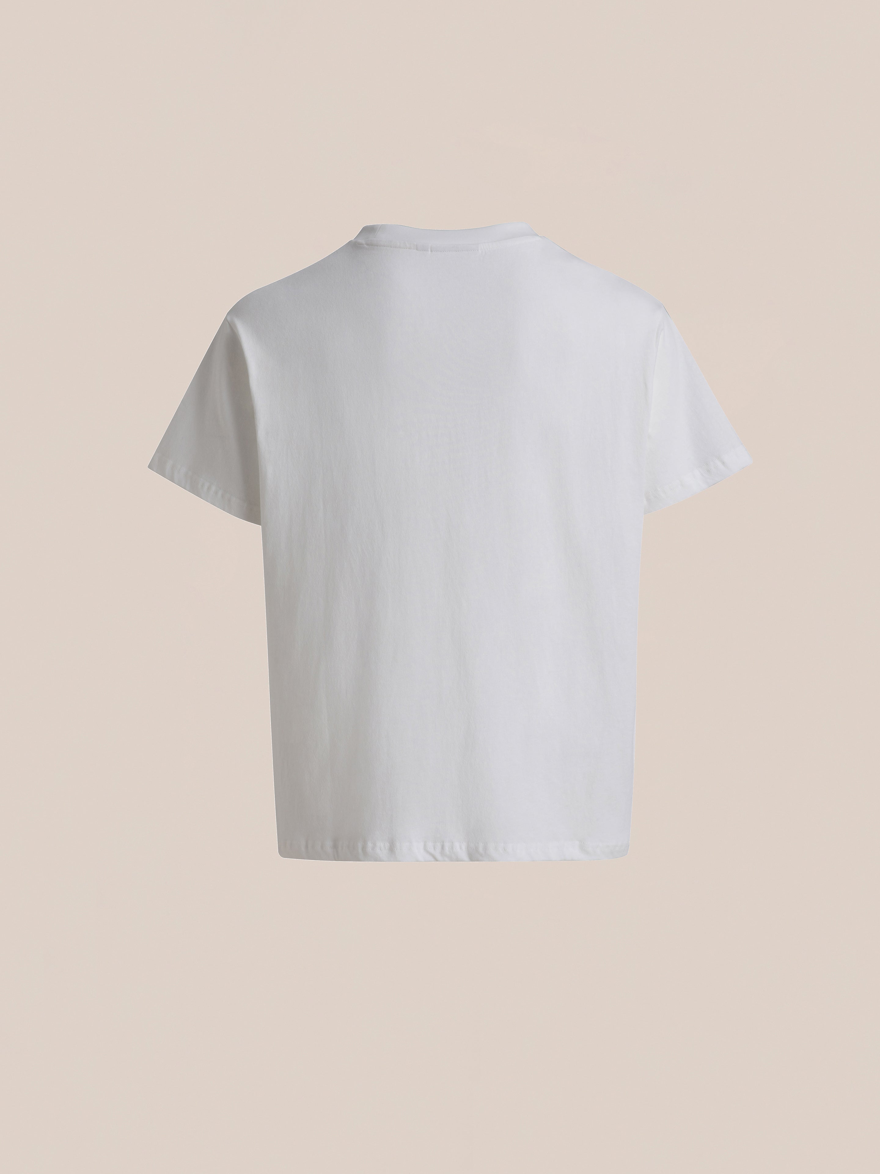 Rear view of a plain white Malibu Farm Fair Tee by FOUND, made from 100% cotton, against a light beige background.