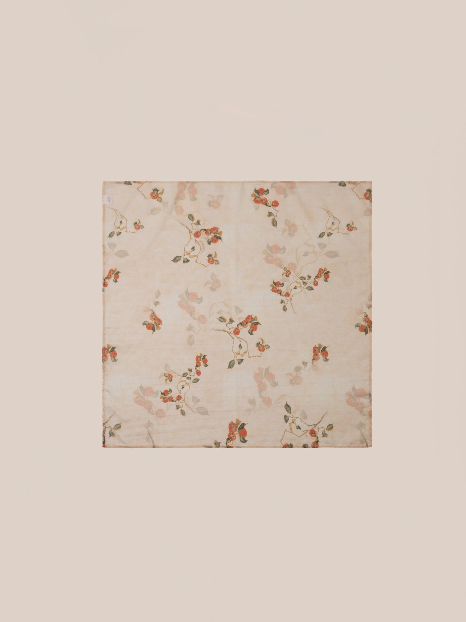 Introducing the Roshan Floral Bandana by FOUND, featuring a beautiful floral pattern with orange and green flowers set against a light beige background.