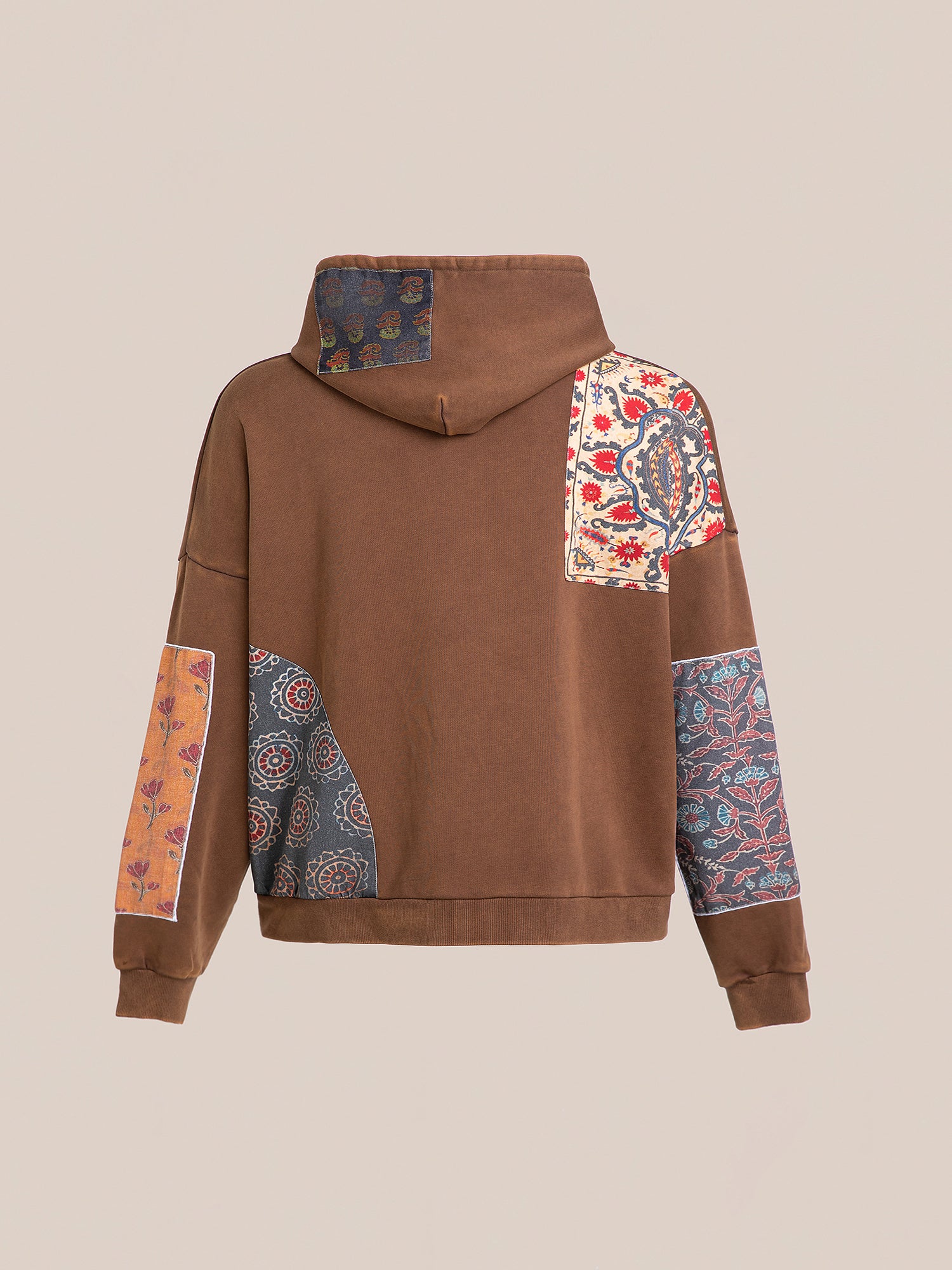 The Patchwork Hoodie by FOUND features a cotton terry fabric adorned with intricate South Asian patterns in vibrant floral designs on the back and sleeves.