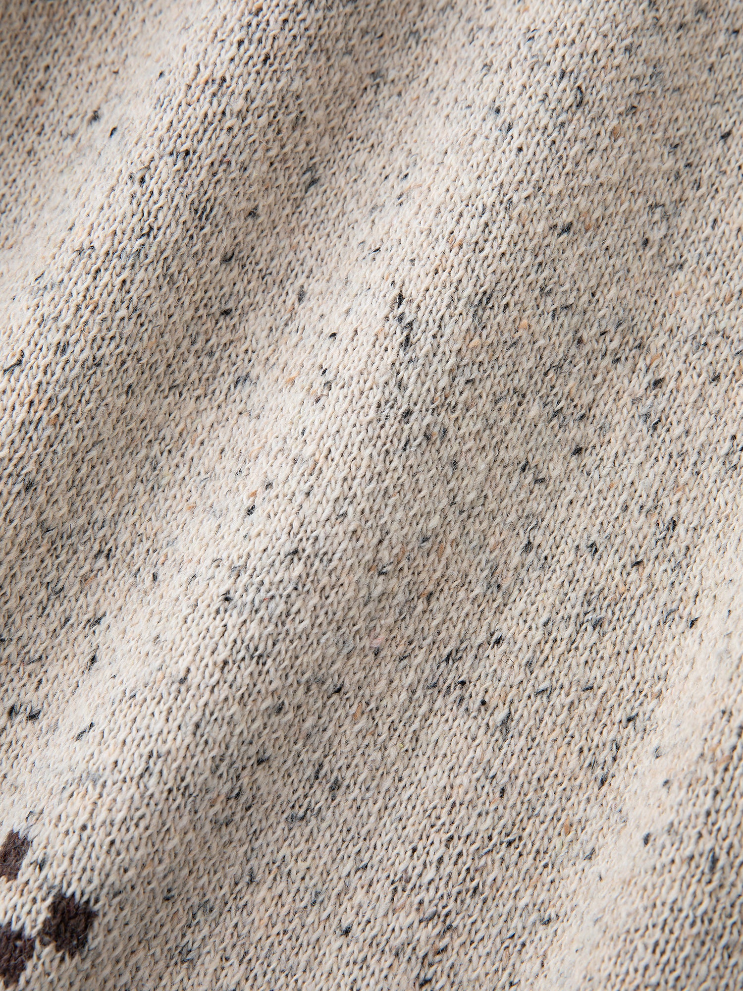 Close-up of the Speckled Knit Horse Sweater by FOUND, featuring a wool blend with a speckled pattern in beige, gray, and brown tones.