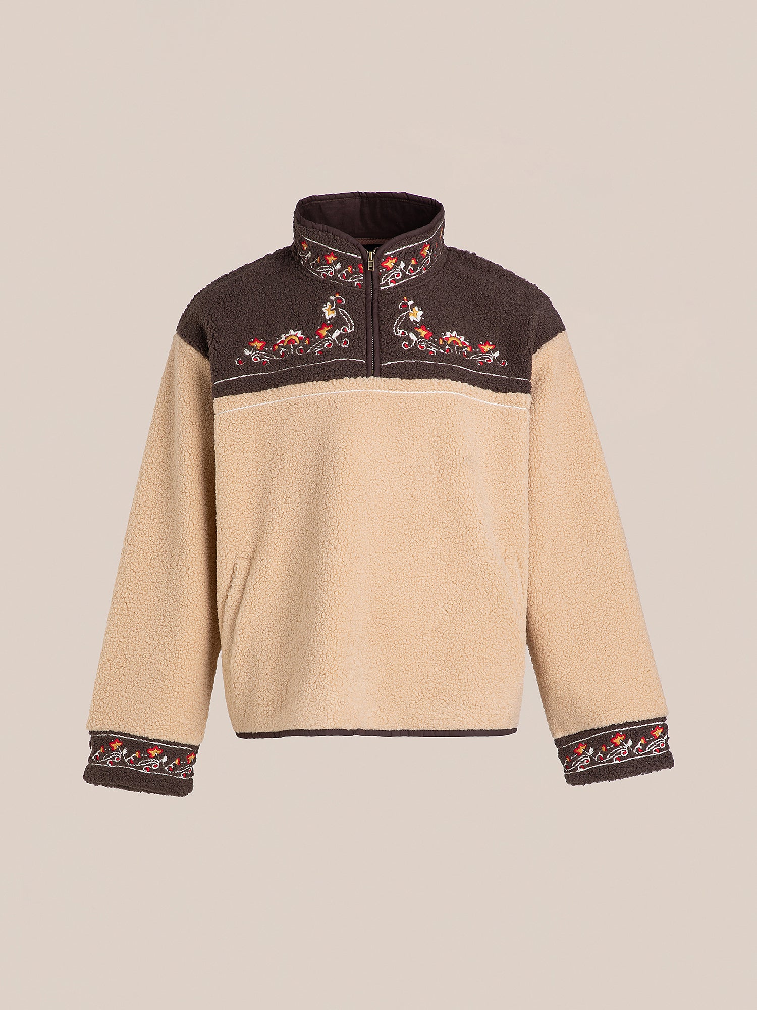 The Pahari Floral Embroidered Sherpa Pullover by FOUND features a beige design with dark brown accents and floral embroidery on the collar, chest, and sleeves.