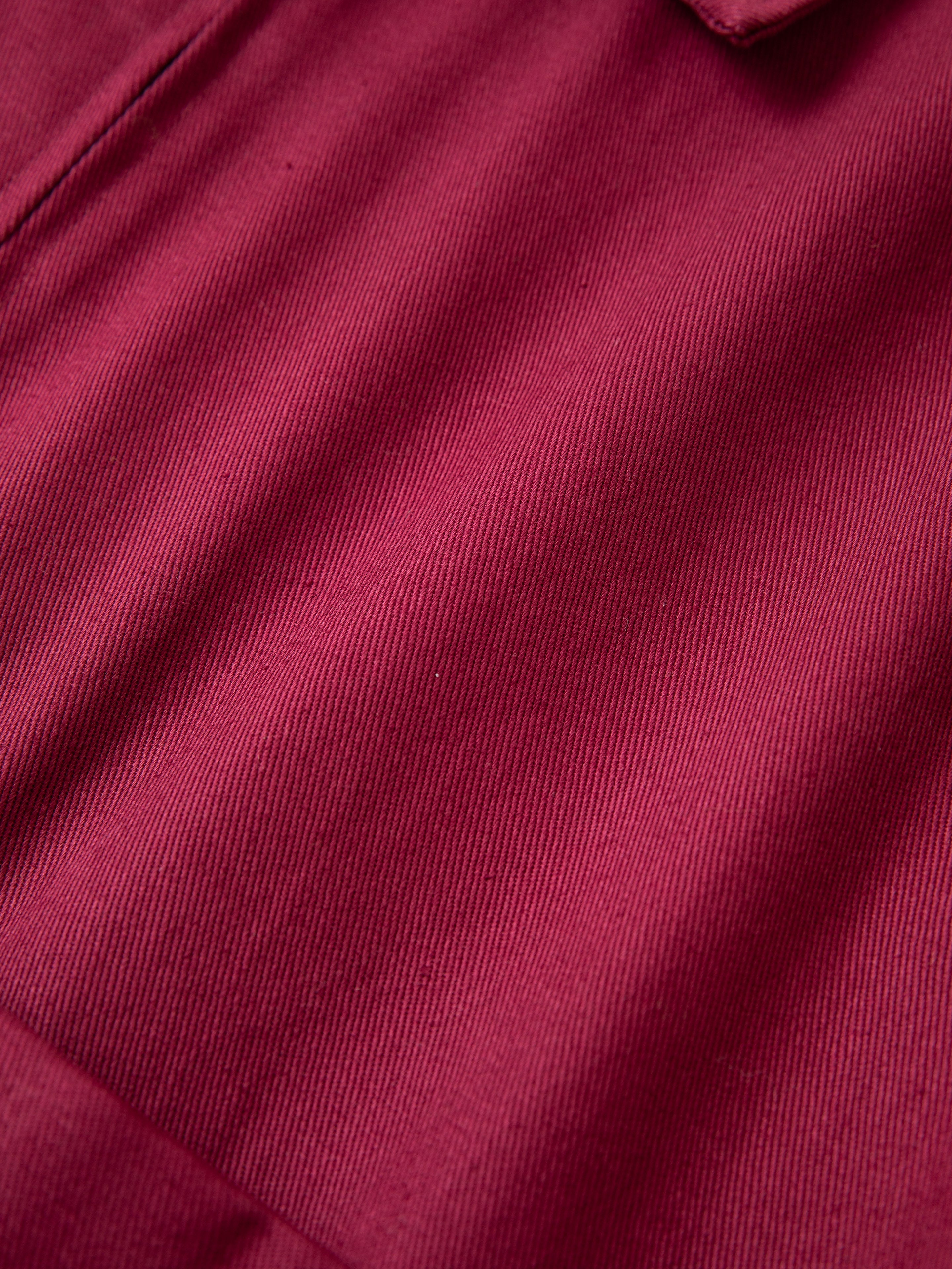 Close-up of an Oxblood Horse Equine Jacket by FOUND, showcasing its weave and texture, reminiscent of 70's jockey uniforms crafted from lightweight cotton twill.