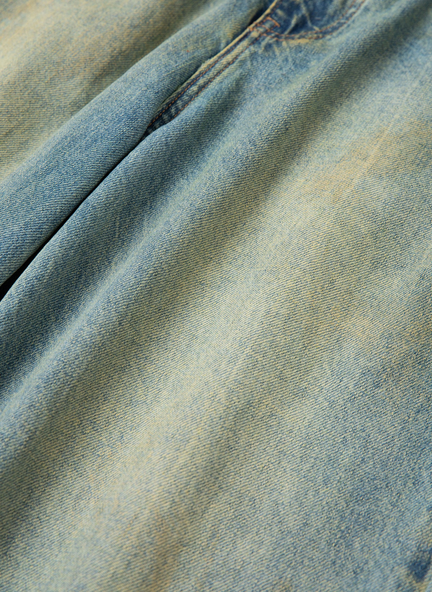 Close-up of the Lacy Baggy Jeans by FOUND, showcasing light blue denim fabric with subtle fading, light distressing, and visible stitching along a seam.