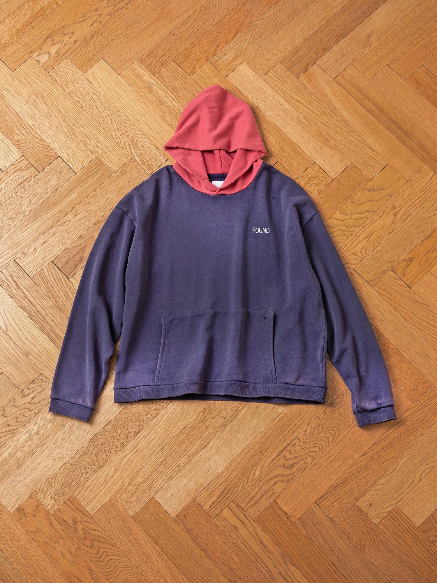 The Distressed Logo Hoodie from FOUND, featuring a purple body with a red hood and 