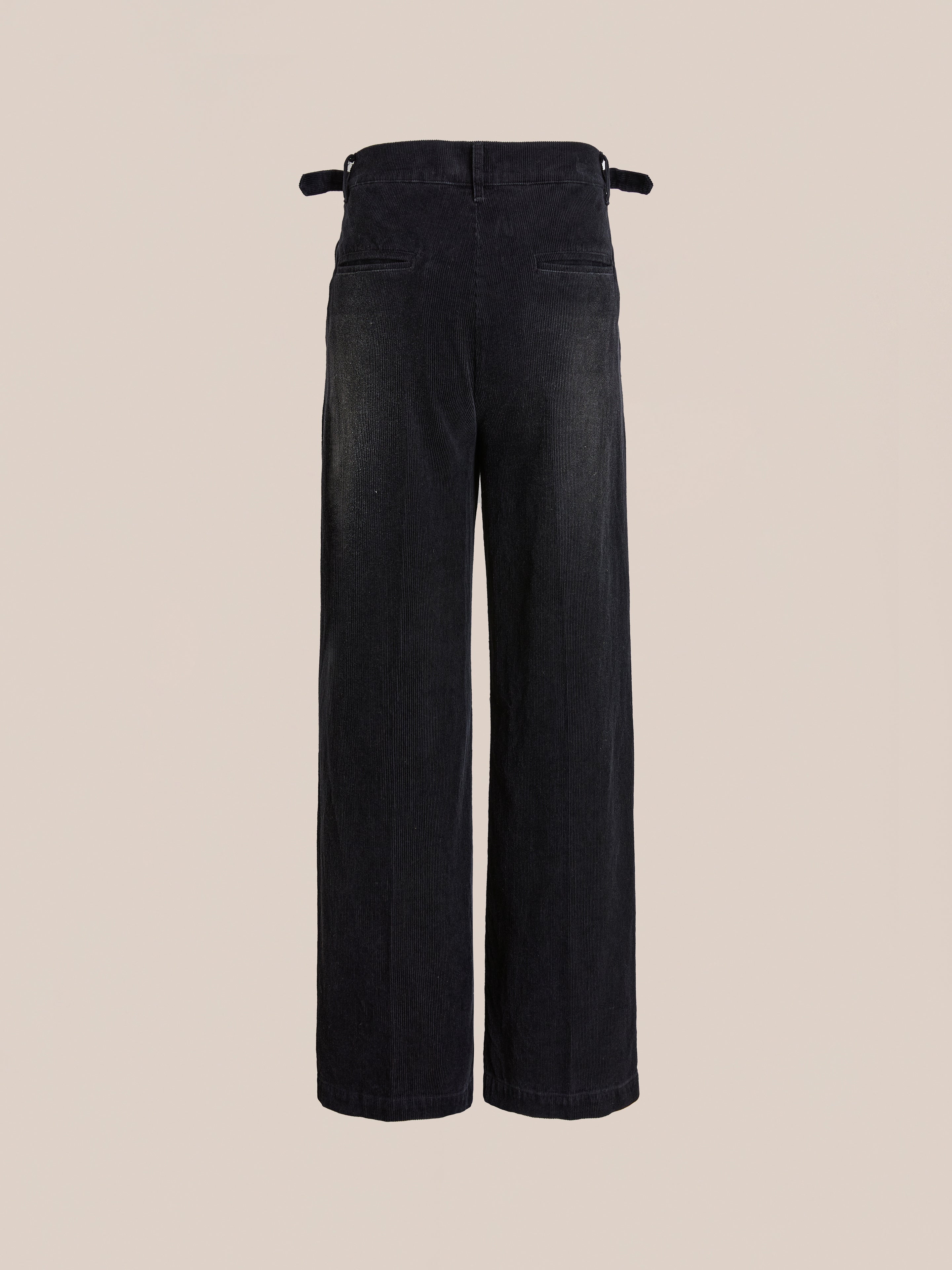 FOUND Faded Pleated Corduroy Pants feature a high waist, wide legs, double pleats, two back pockets, and adjustable side tabs, shown on a plain beige background.