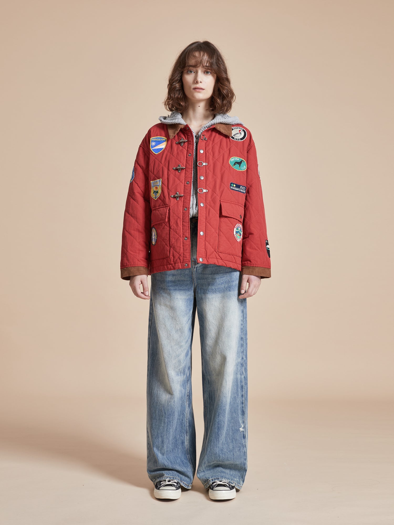 A woman wearing a Farmstead Quilt Patch Jacket by Found and jeans.