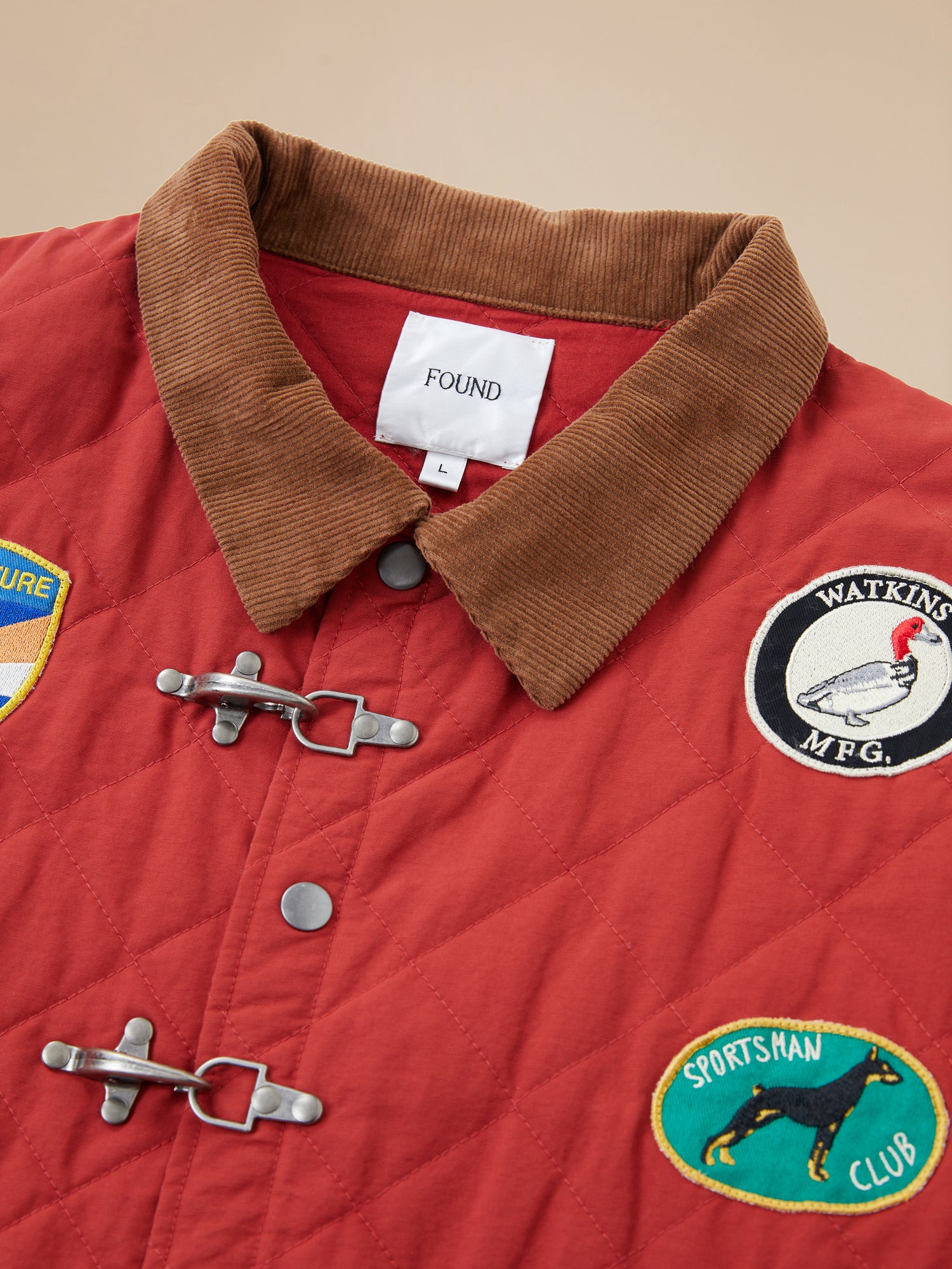 A red Farmstead Quilt Patch Jacket from Found with patches on it.