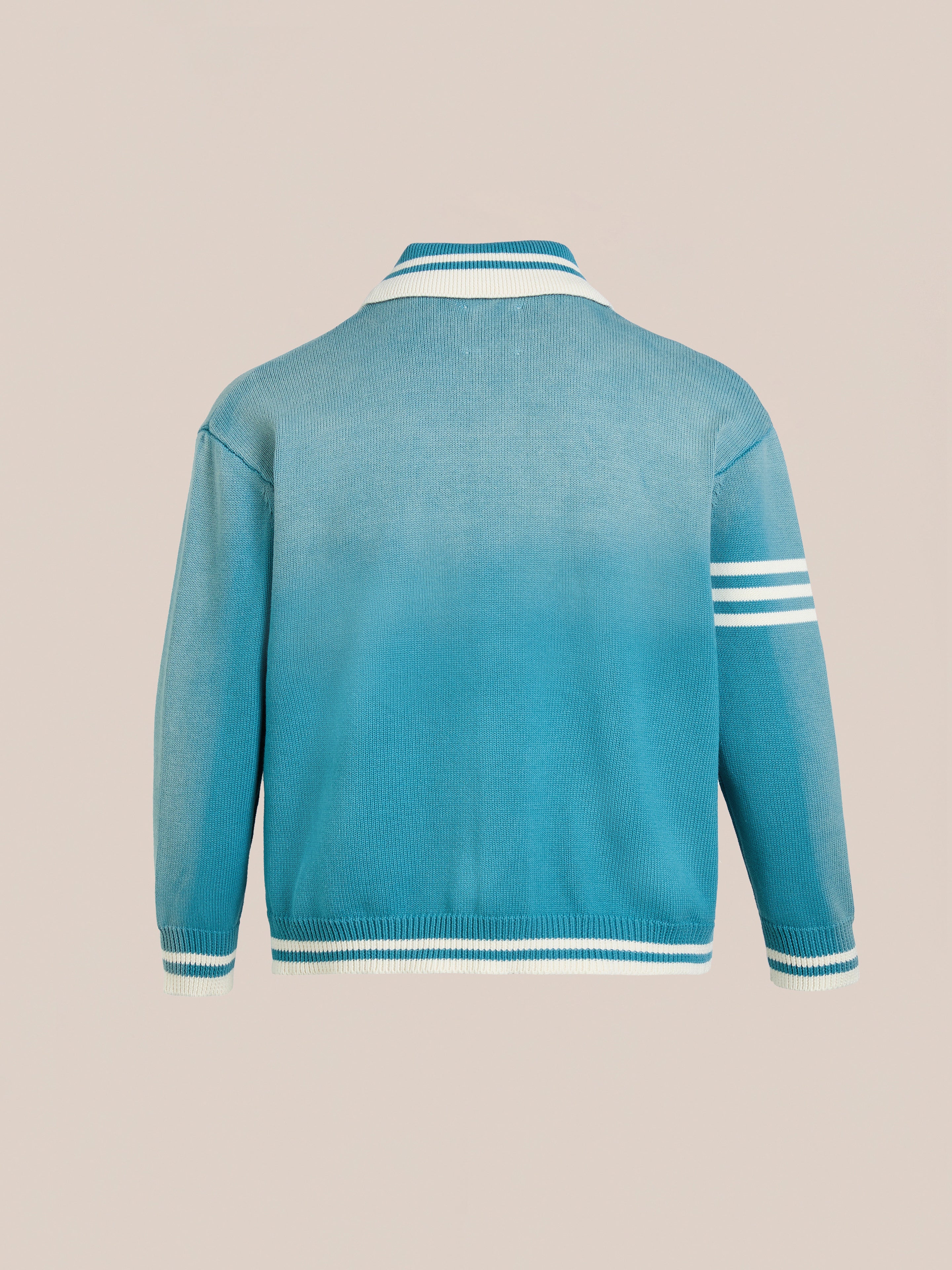 The Fin Varsity Patch Collared Cardigan by FOUND is a blue varsity-style jacket with white striped cuffs, collar, and single-arm detail. Displayed from the back, it exudes classic collegiate style that honors tradition.