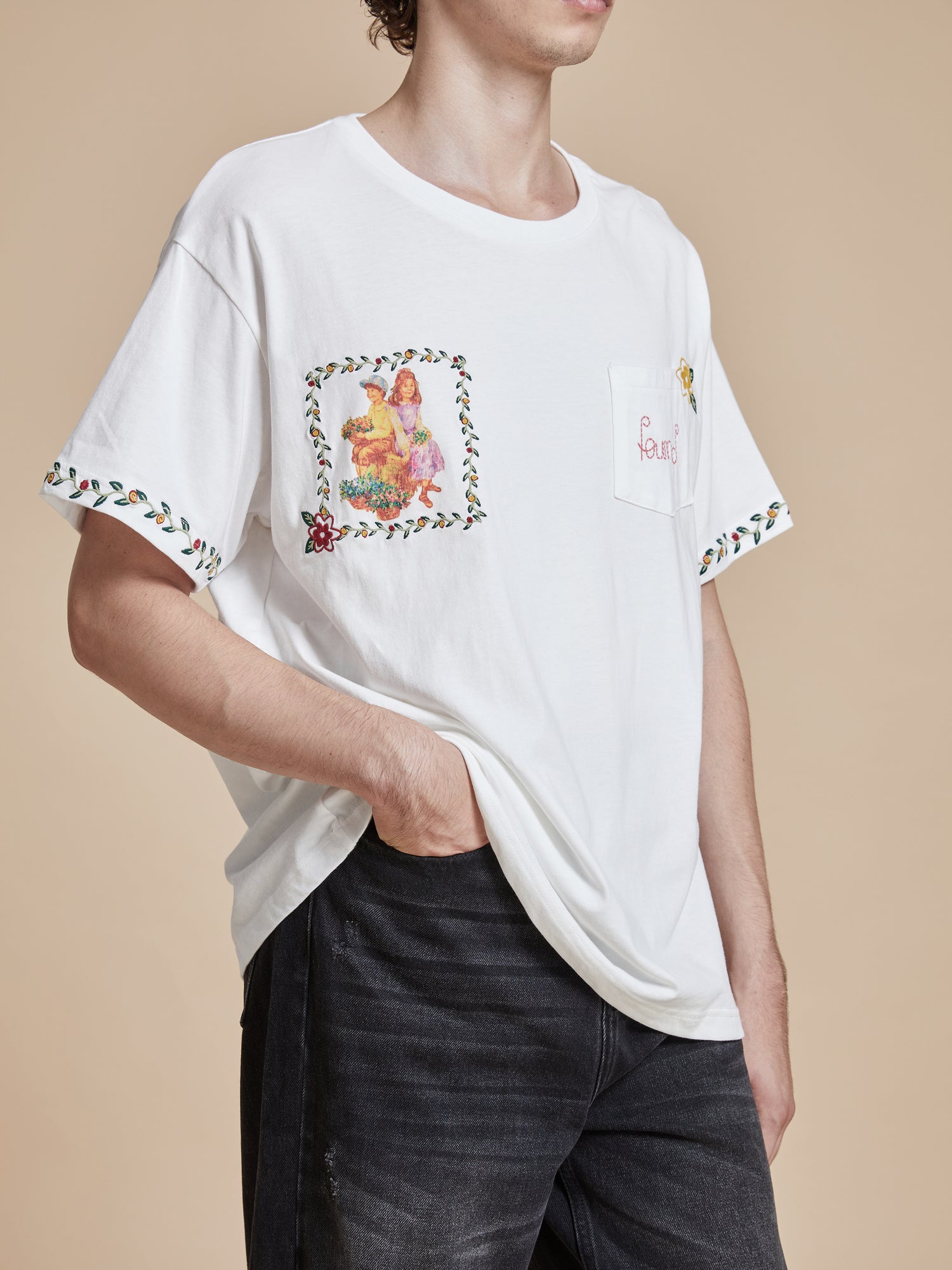 A man wearing a Found Flower Children Tee with floral Phulkari style embroideries.