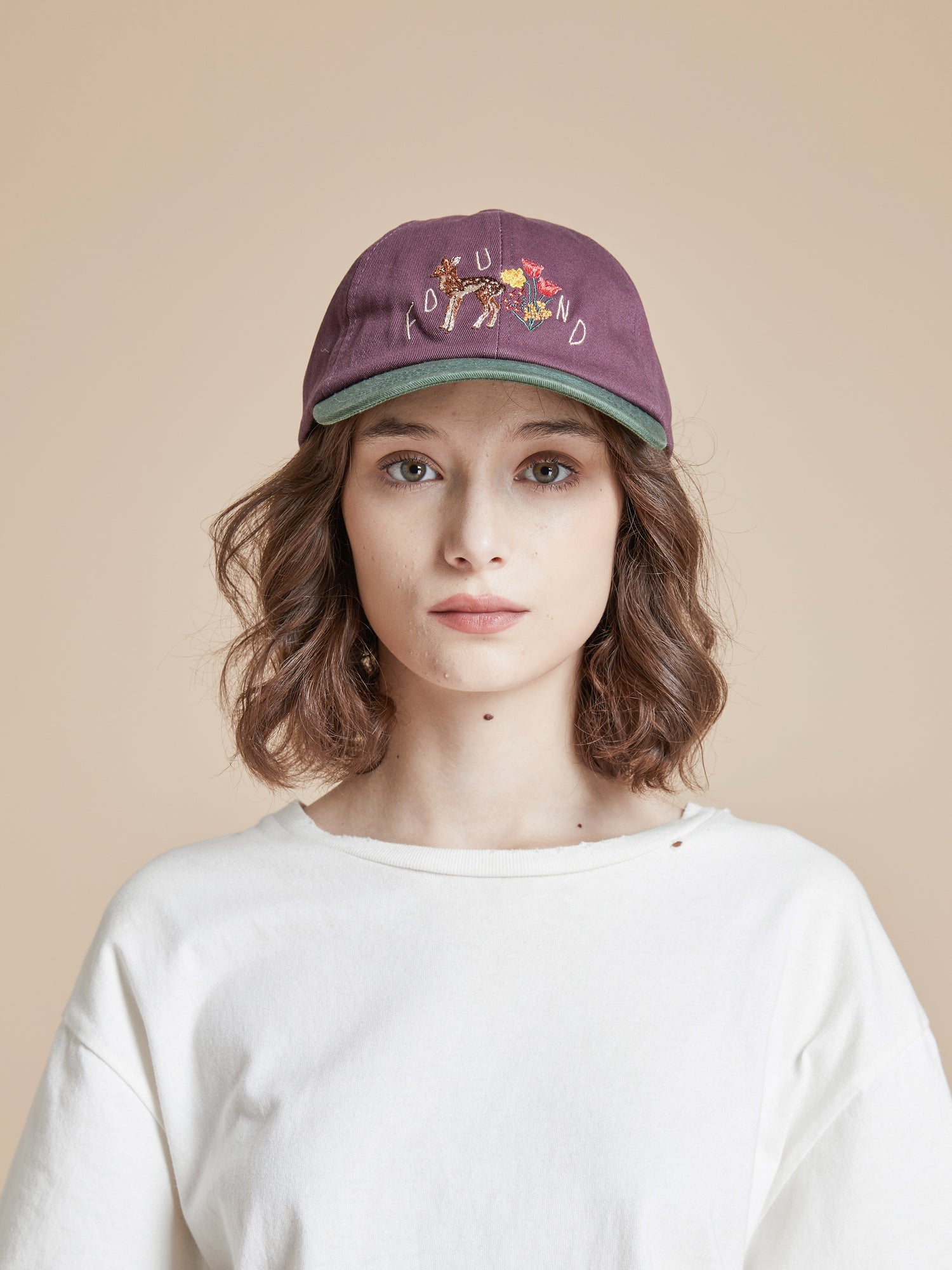 A woman wearing a Found Flower Deer Cap baseball cap.
