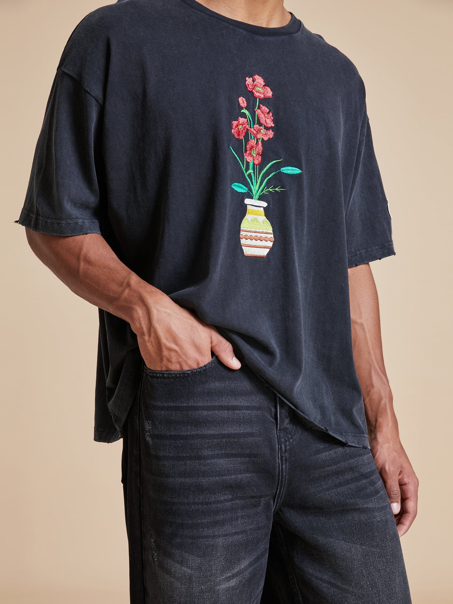 A man wearing a Found Flowers Vase tee.