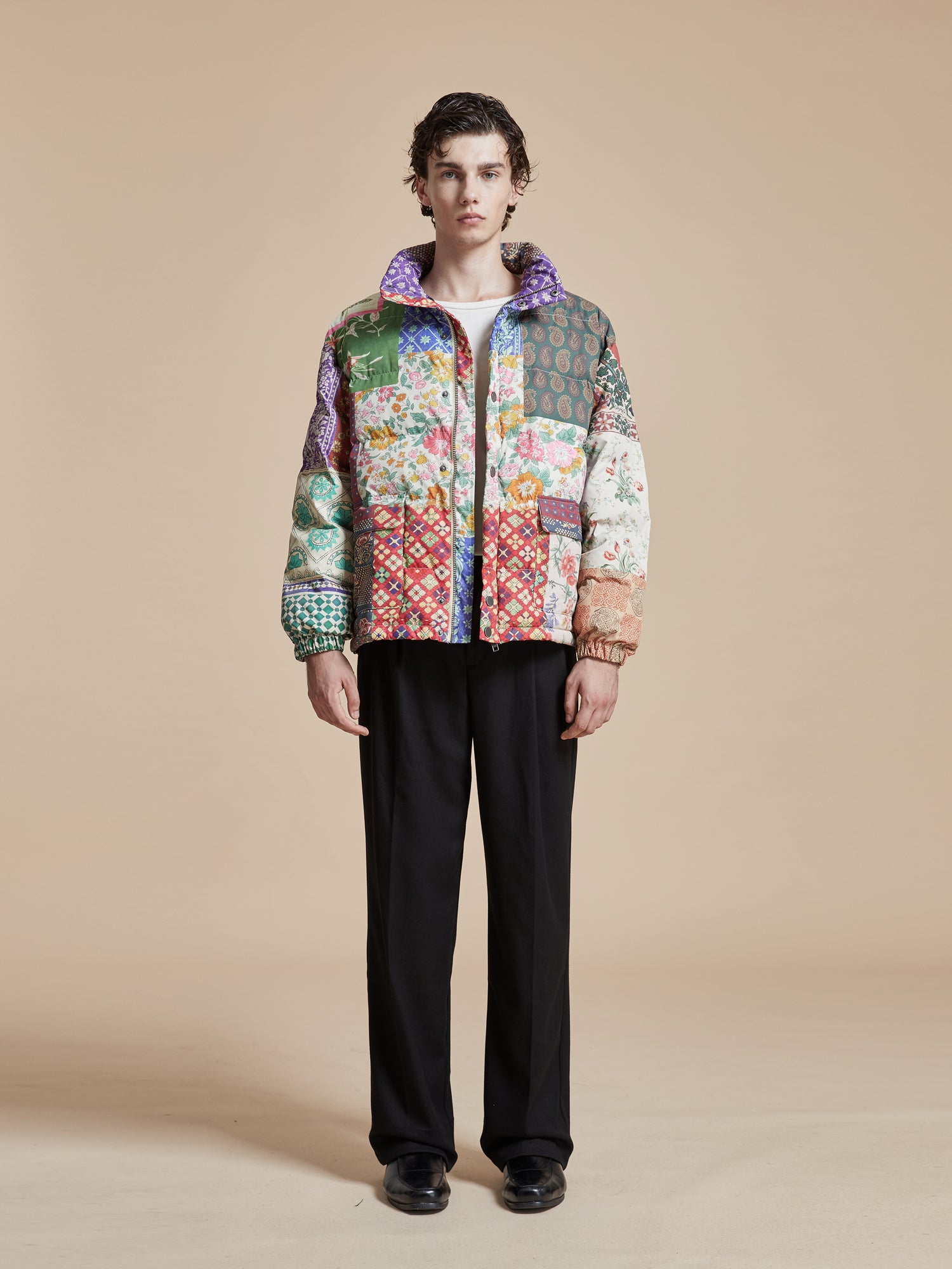 A man wearing a multicolored Gardenia Tapestry Puffer Jacket.