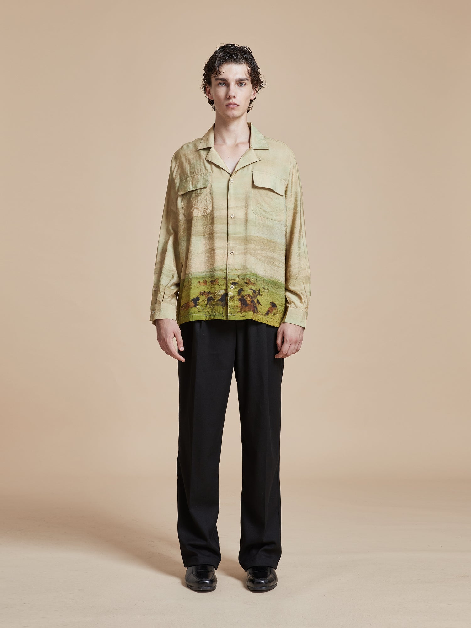 A model wearing a nature-inspired Grasslands Long Sleeve Camp Shirt with a print on it, inspired by Phulkari motifs, from the brand Found.