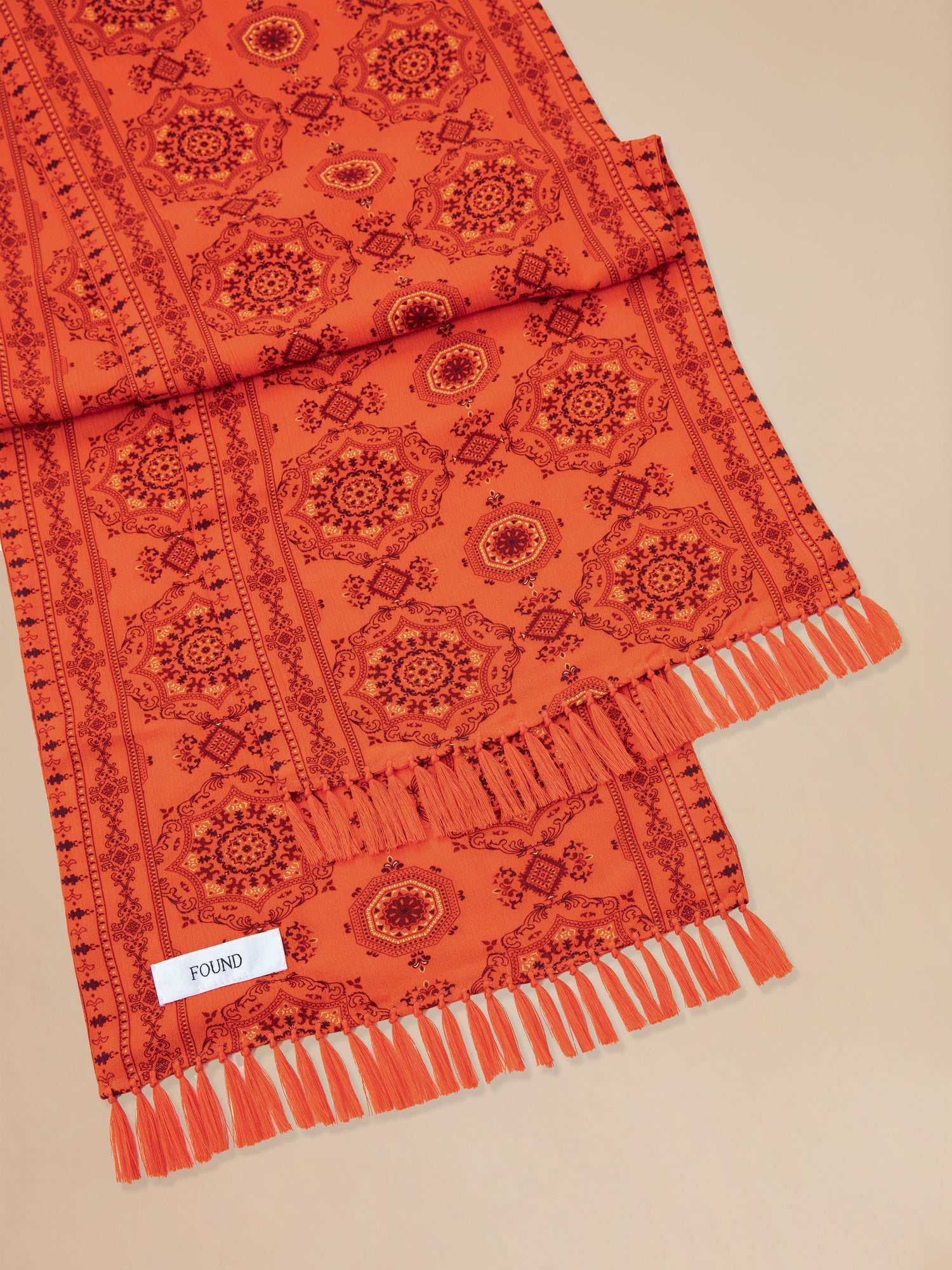 An orange Found Grenadine scarf with hand-tied tassels.
