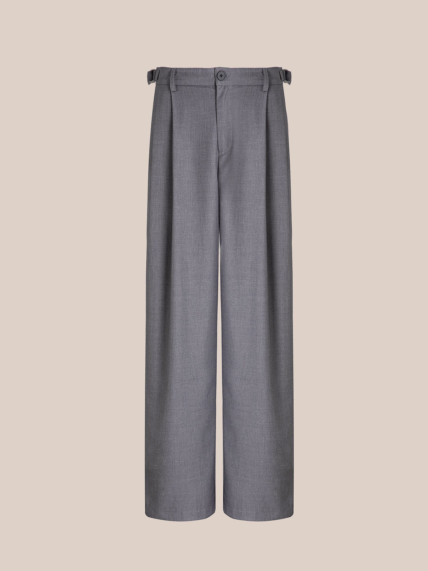 FOUND's Pleated Trousers feature a high-rise, gray wide-leg design with double pleats, button closure, and adjustable side tabs, all set against a simple beige backdrop.