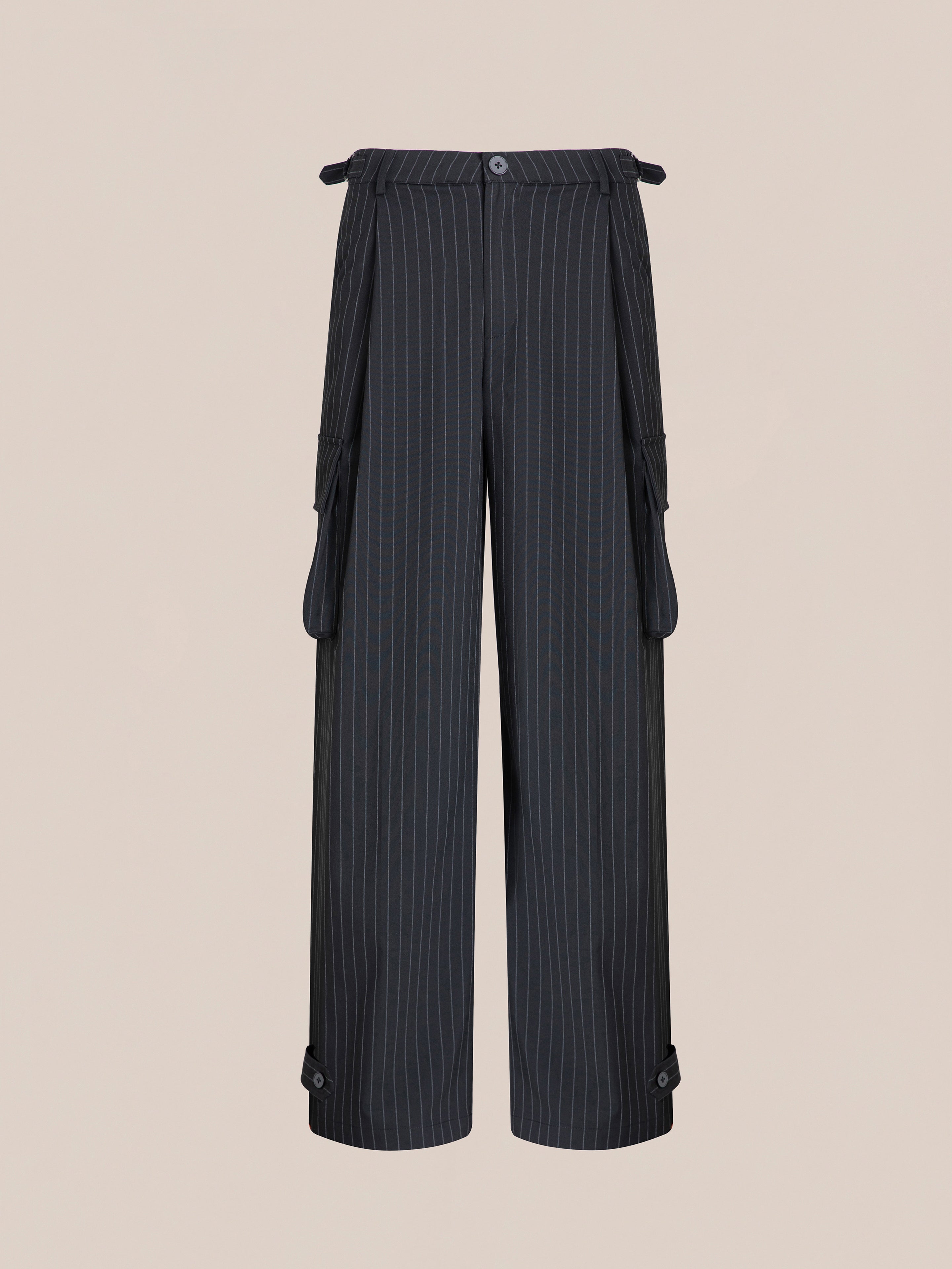 The Hava Pinstripe Pleated Cargo Trousers by FOUND are black, wide-leg, cotton-blend pants featuring button and strap detailing on the waistband and ankles.