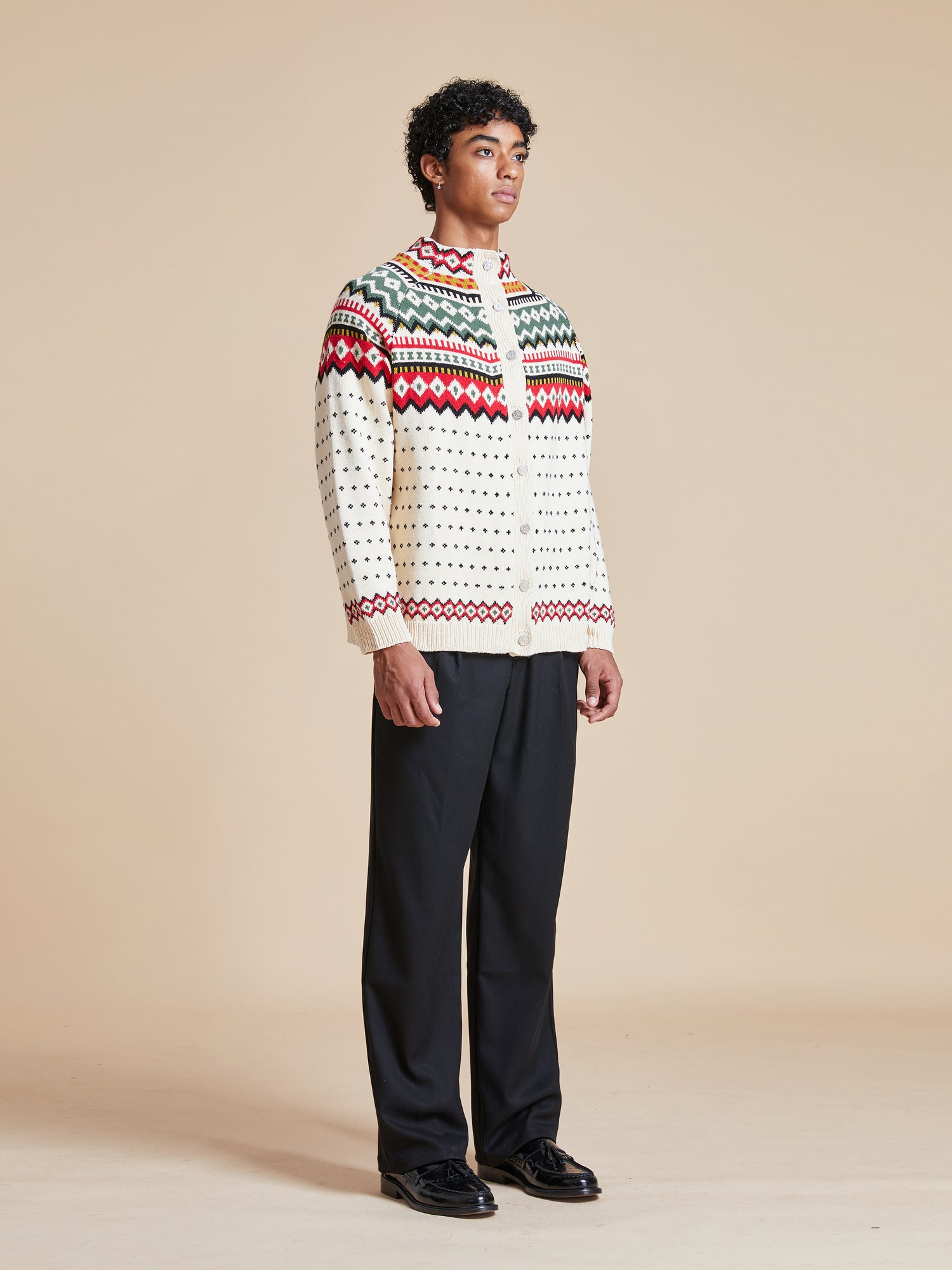 A man wearing a Harwan Isles Sweater and black pants from the Scottish Fair Isle region, made by Found.