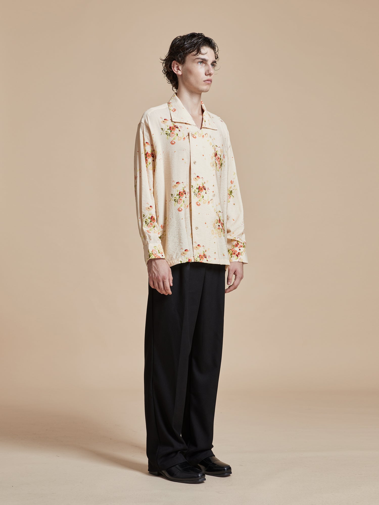 A model wearing a Found Kanhati Garden Long Sleeve Camp Shirt with Phulkari motifs, paired with black pants.