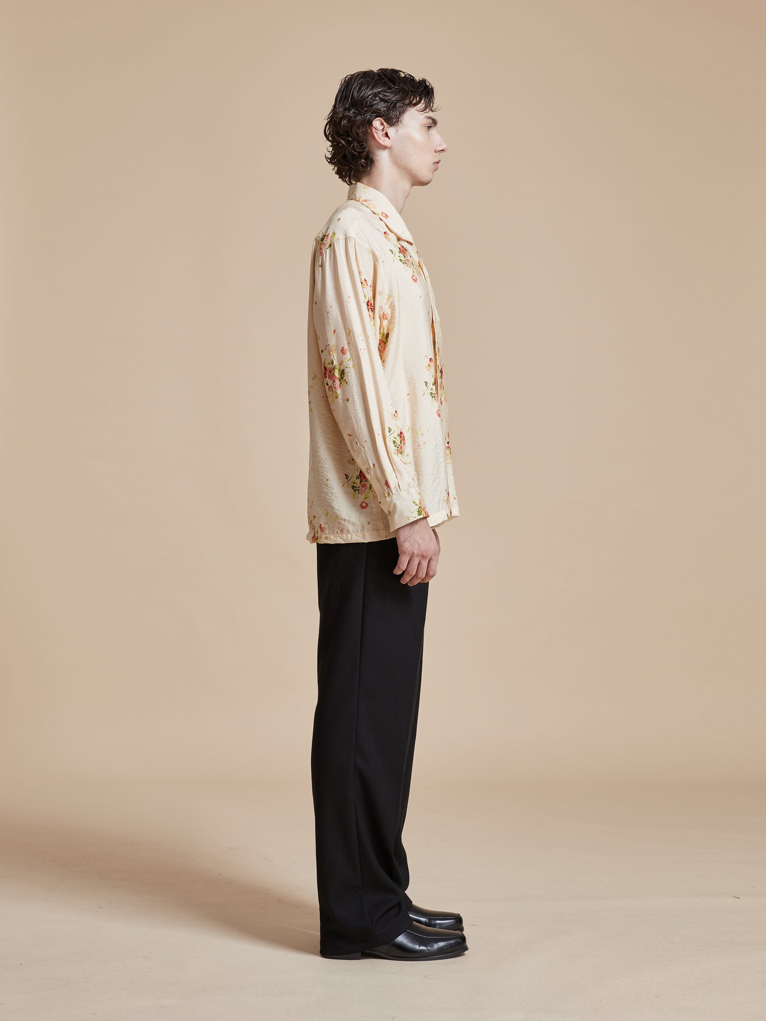 A man standing in front of a white background wearing a Found Kanhati Garden Long Sleeve Camp Shirt and pants.