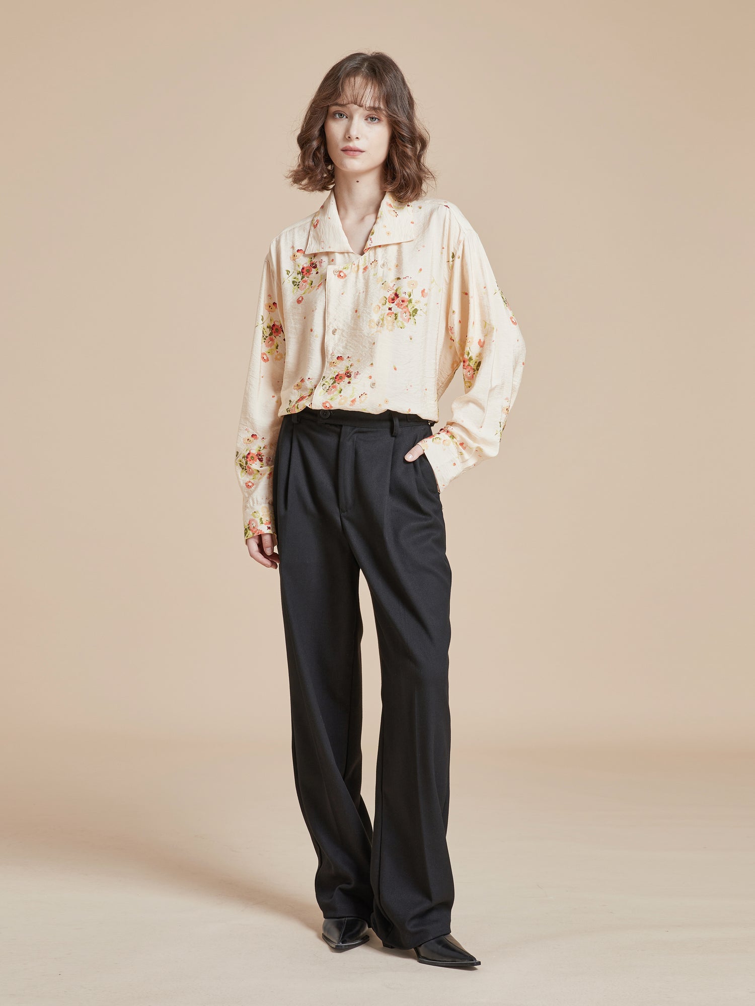 A model wearing a Found Kanhati Garden Long Sleeve Camp Shirt adorned with Phulkari motifs and paired with black wide leg pants.